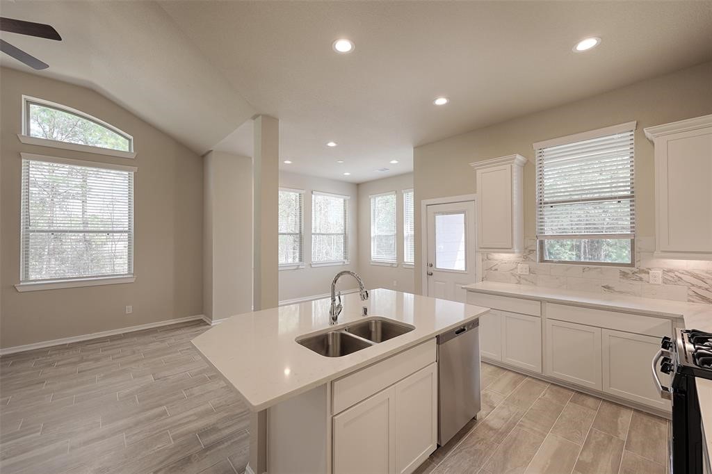 Large dining area overlooks lush trees side and rear.