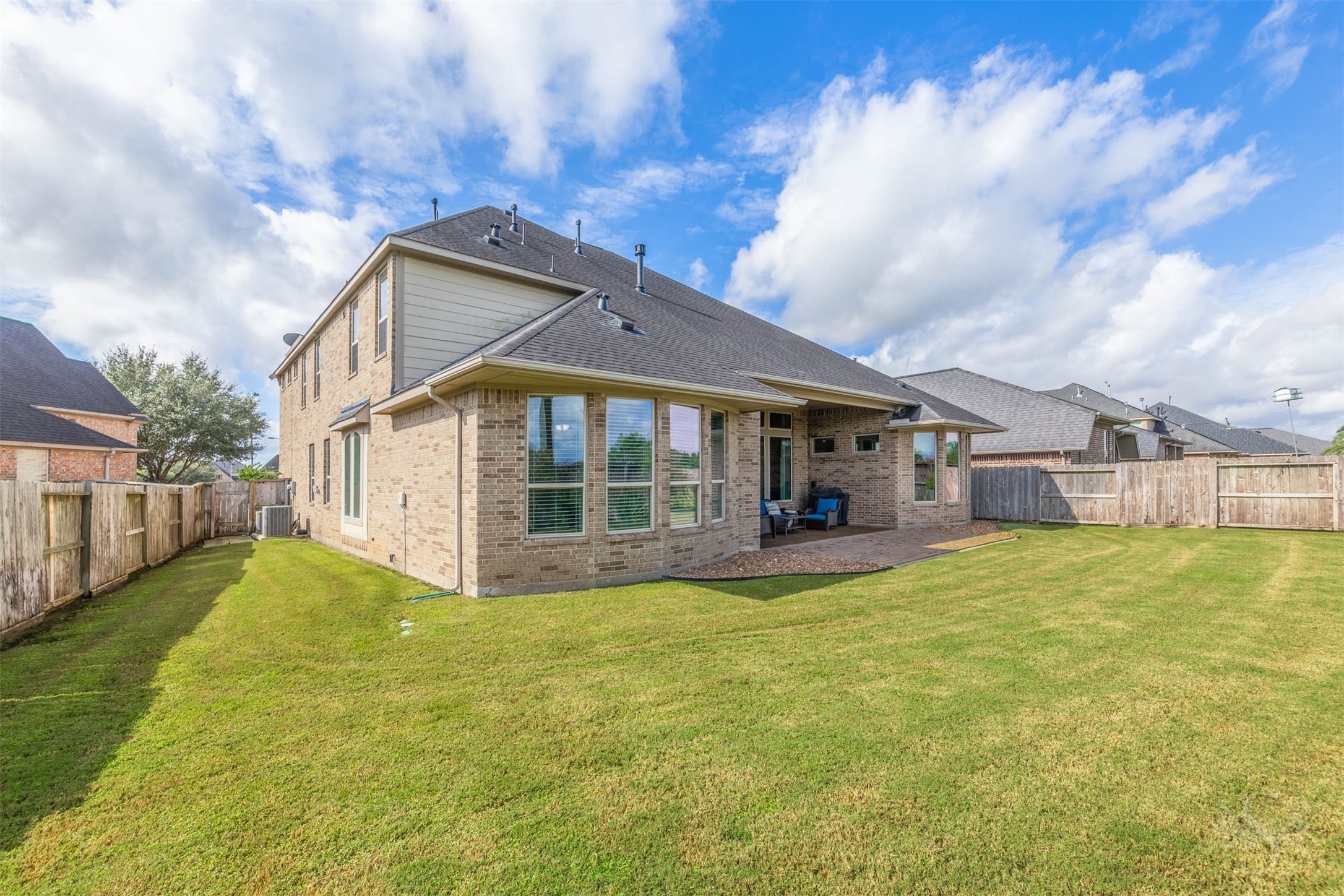 An expansive lawn wraps around the home, providing abundant space for outdoor games, gardening and family fun. The covered patio and adjoining paver extension offer a welcoming setting for relaxed evenings and weekend entertaining.