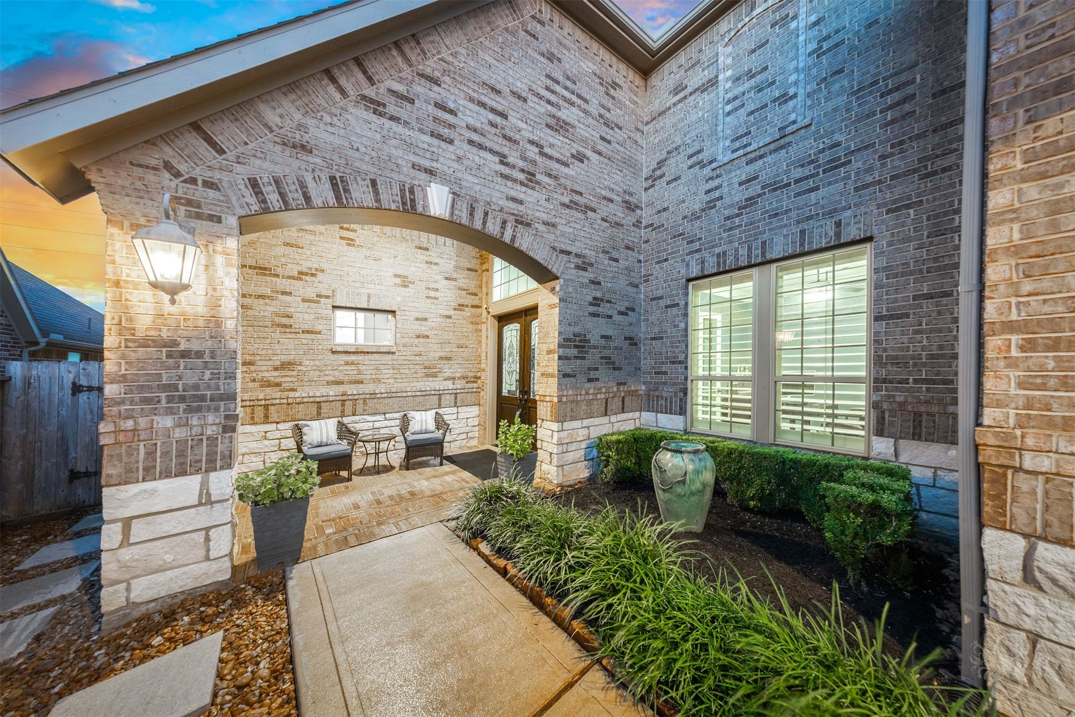 A graceful brick arch and elegant lantern lighting welcome you into the beautifully landscaped front courtyard. The sheltered porch offers a charming place to sit and unwind beside the decorative glass double doors. A graceful brick arch and elegant lantern lighting welcome you into the beautifully landscaped front courtyard. The sheltered porch offers a charming place to sit and unwind beside the decorative glass double doors.