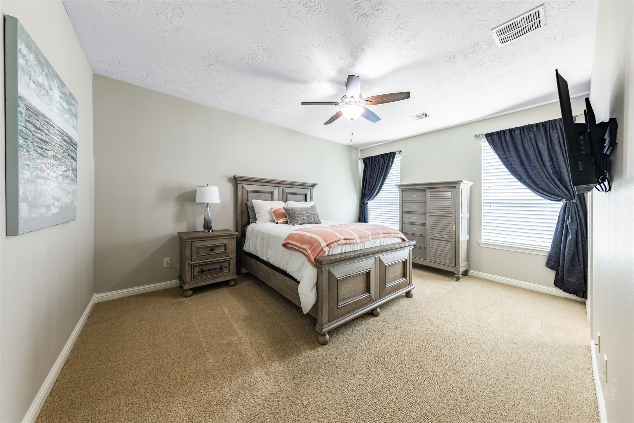 This spacious upstairs bedroom offers a bright, welcoming retreat with two large windows and soft neutral finishes. Generous proportions provide comfortable space for bedroom furnishings and a study area.