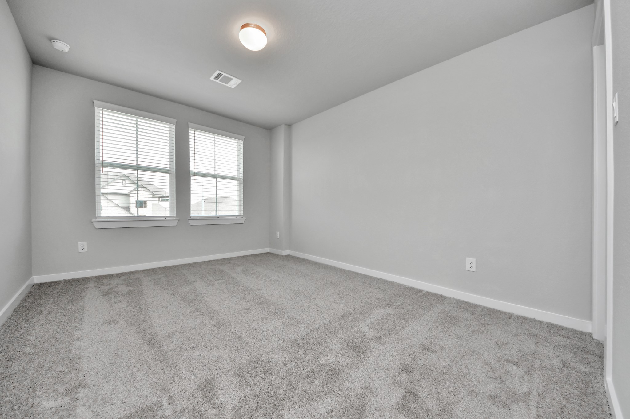 Secondary bedroom features plush carpeting, large windows that let in plenty of natural light, bright paint, and spacious closets. Sample photo of completed home with similar floor plan. Actual colors and selections may vary.