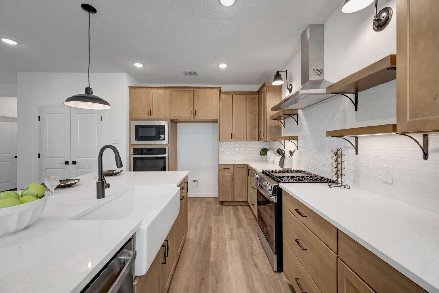 Stylish kitchen with light stain cabinets and floating shelves