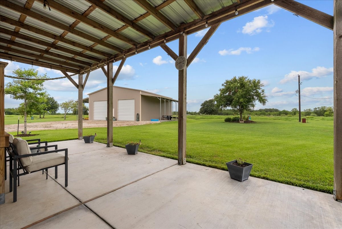 What a view of the backyard! The perfect spot with cover to enjoy your morning coffee, your favorite beverage, or relax with family and friends during gatherings