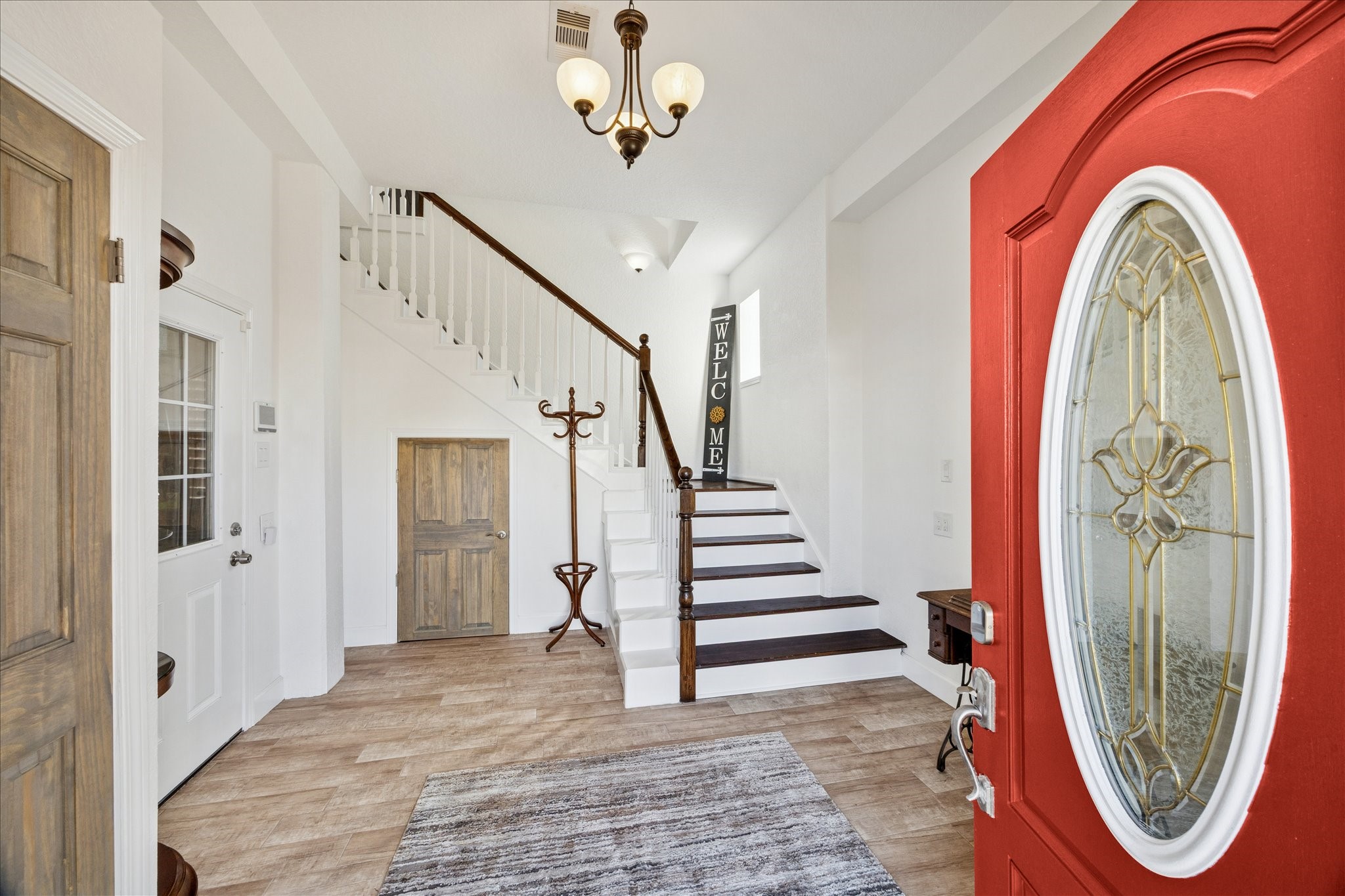 Ground-floor entry welcomes you with natural light and distinctive style. Solid stained wood doors throughout add warmth, while the wide staircase leads to the home's upper living spaces.