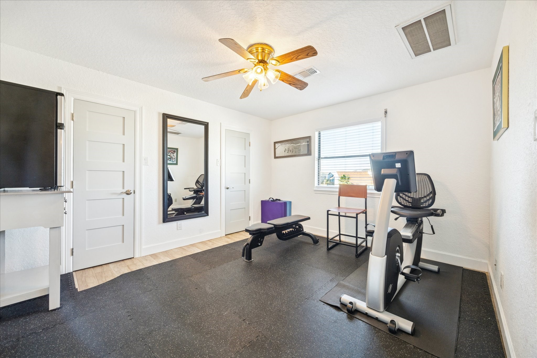 Currently configured as a workout room, this second-floor bedroom can easily return to its intended use. An ensuite bath and two closets with wall-to-wall storage add everyday function.