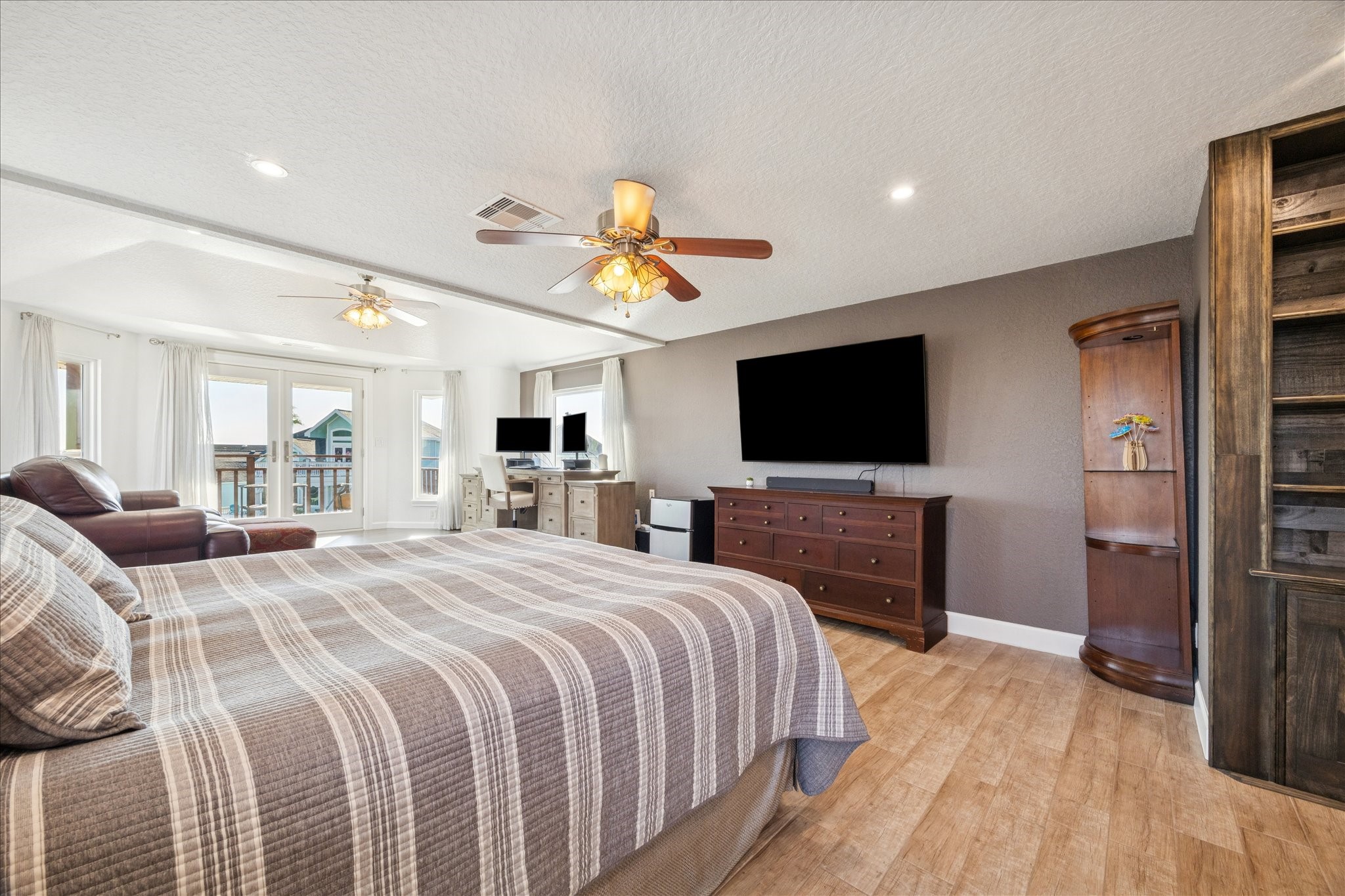 Remarkable scale gives the primary bedroom exceptional versatility, accommodating an extensive range of furniture choices and arrangements. Wood-like plank tile continues here and throughout the home.
