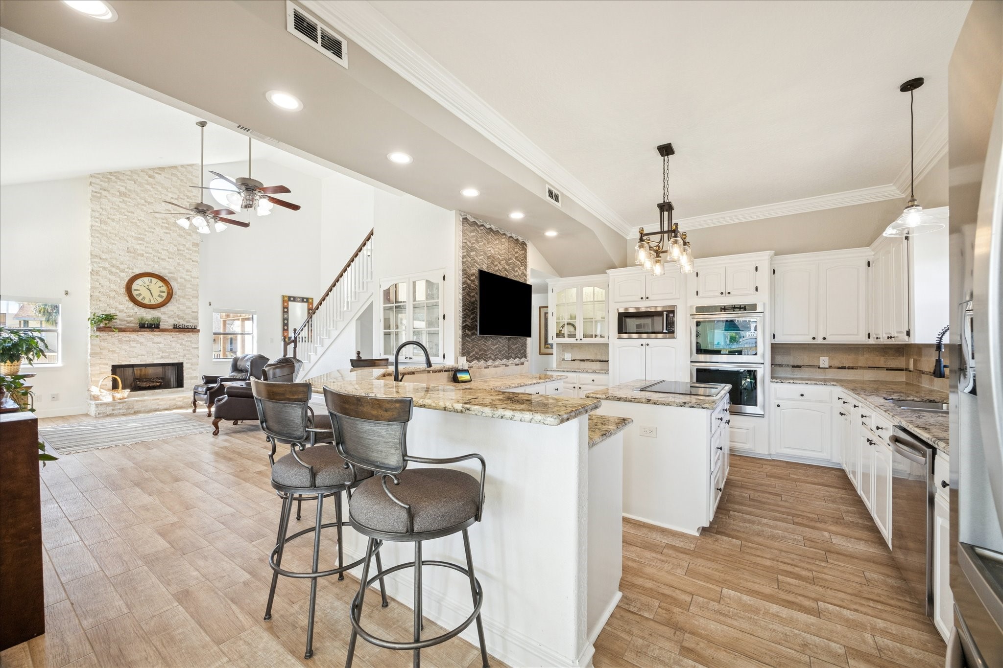 Open to the family room, the kitchen keeps everyone connected, whether cooking, gathering around the bar, or entertaining friends and family.