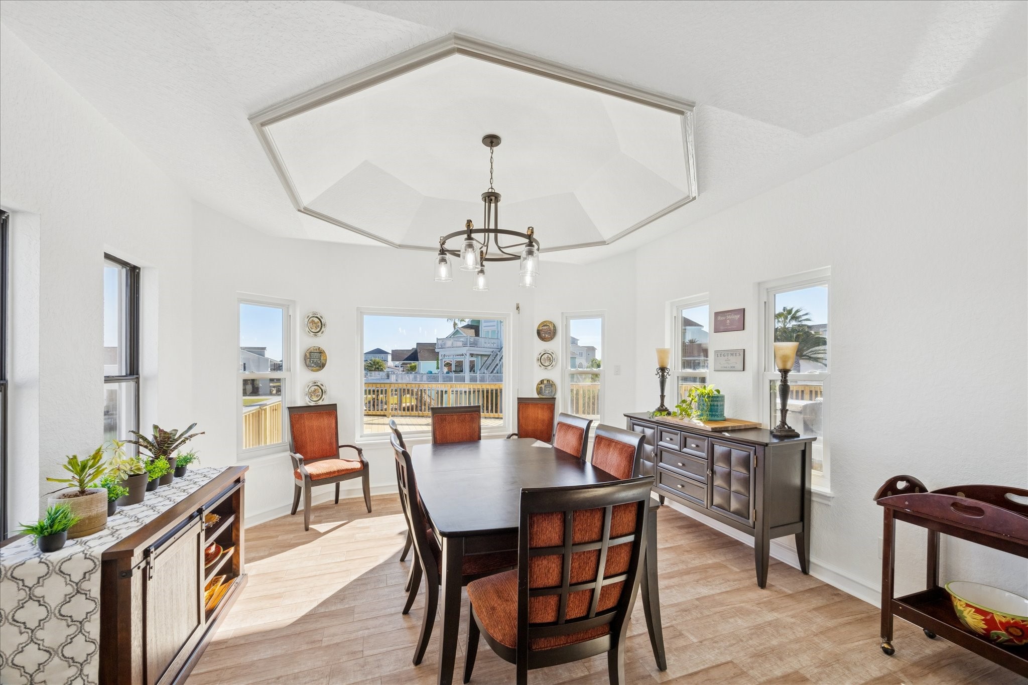 Surrounded by windows on three sides, the dining room captures water views while staying connected to the kitchen and family room. A striking hexagonal ceiling overlooks the space.