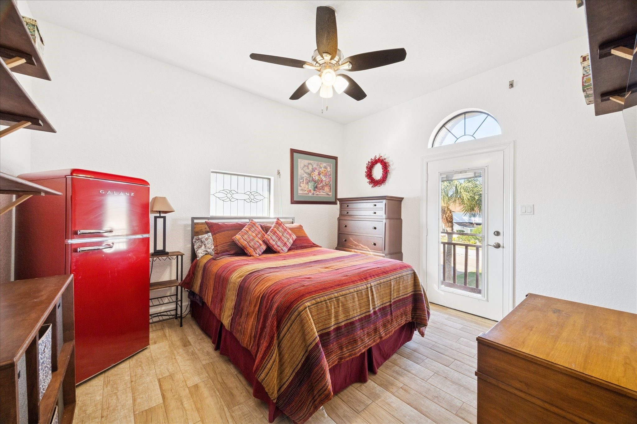 This comfortable bedroom with a patterned-glass window, custom shelving and its own private balcony, giving guests or family their own place to step outside and unwind.