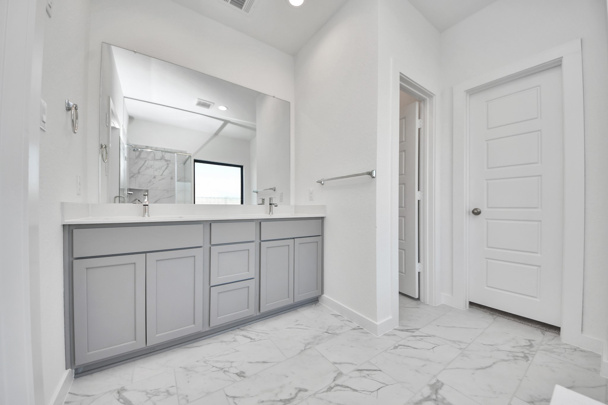 Escape to a spa-like oasis in this primary bathroom. Enjoy a walk-in shower with tile surround, a separate garden tub with custom detailing, and an elegant vanity featuring light countertops, modern hardware, and beautiful vanity lights. Experience luxury and relaxation in every detail. Sample photo of completed home with similar floor plan. Actual colors and selections may vary.