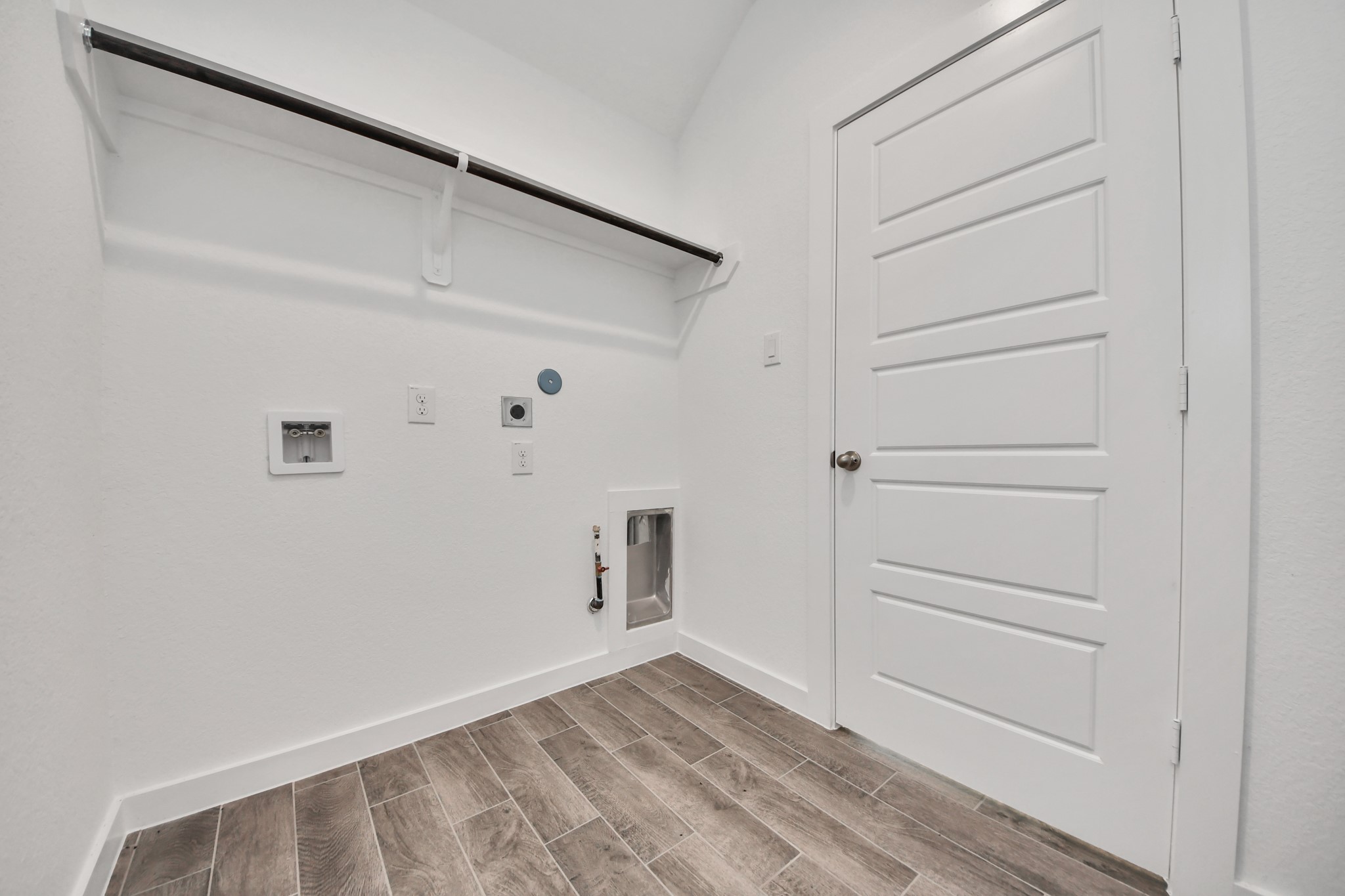 A perfect blend of functionality and comfort. Capture the essence of easy living with a first-floor laundry room, thoughtfully equipped with shelving for effortless organization. Both electric and gas connections available. Sample photo of completed home with similar floor plan. Actual colors and selections may vary.