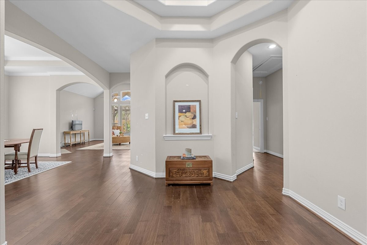 Elegant entrance with beautiful engineered hardwood floors and archways leading to spacious living and dining areas to the left and primary suite to the right with a perfect little powder room for your guests. Elegant entrance with beautiful engineered hardwood floors and archways leading to spacious living and dining areas to the left and primary suite to the right with a perfect little powder room for your guests.