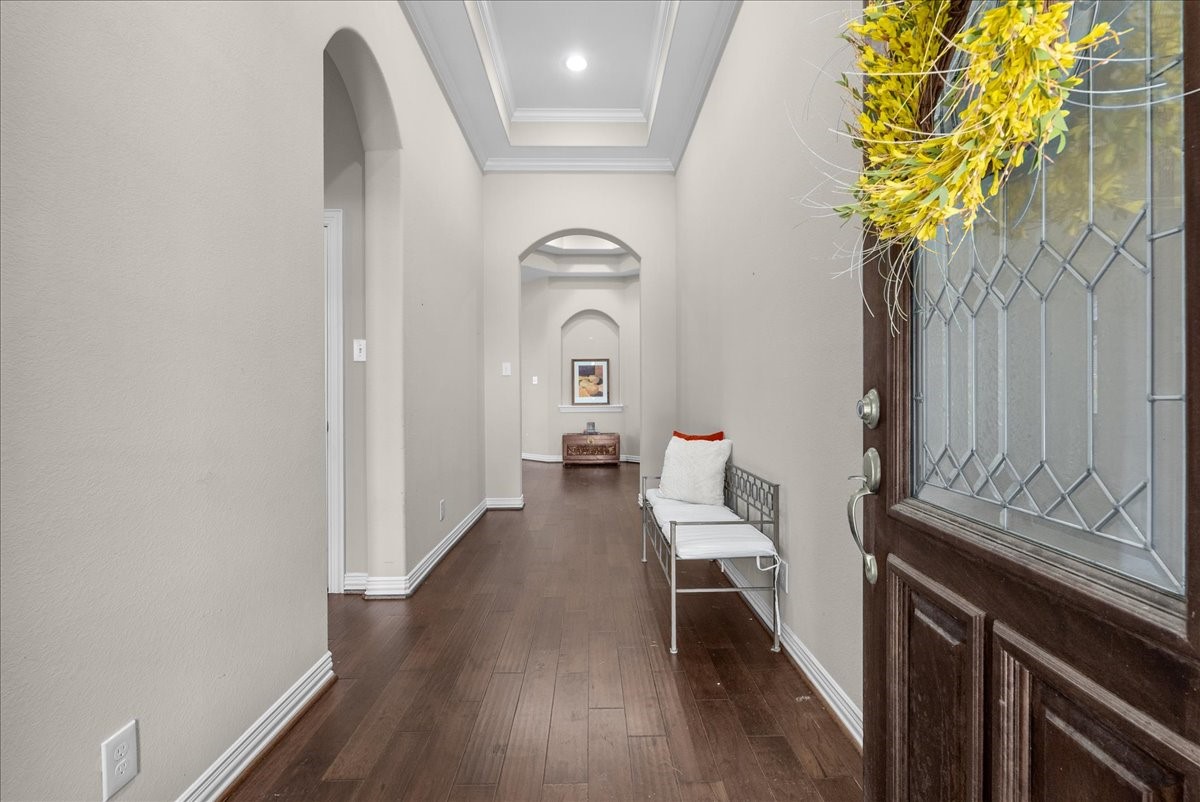 Inviting entryway with elegant hardwood floors, high ceilings, and tasteful archways, offering a warm and welcoming first impression. Inviting entryway with elegant hardwood floors, high ceilings, and tasteful archways, offering a warm and welcoming first impression.