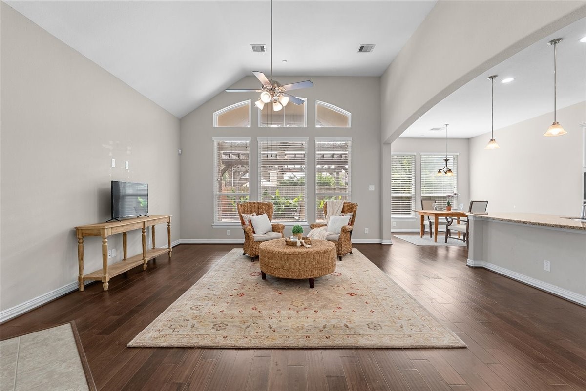 Spacious living area with high ceilings, abundant natural light, and elegant engineered hardwood floors. The open layout seamlessly connects to a cozy dining space and a modern kitchen with stylish pendant lighting. Spacious living area with high ceilings, abundant natural light, and elegant engineered hardwood floors. The open layout seamlessly connects to a cozy dining space and a modern kitchen with stylish pendant lighting.