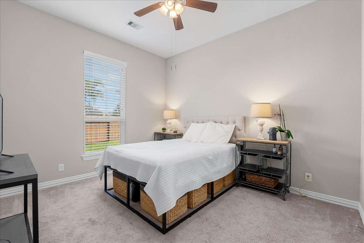 Cozy bedroom #3 with soft neutral tones features ample natural light from the large window.