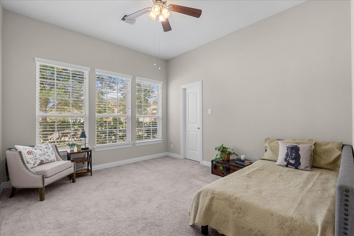 Bright and inviting bedroom with large windows and window coverings that convey with the sale of the house.