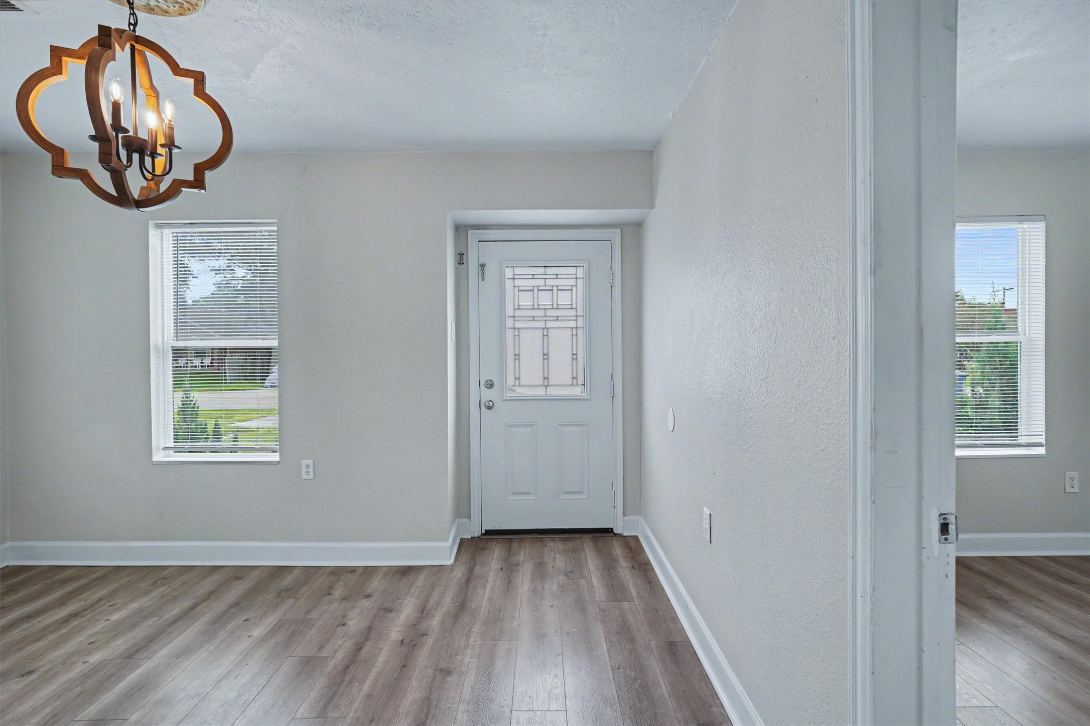 Welcoming front entry with fresh interior paint and wood-look laminate flooring.
