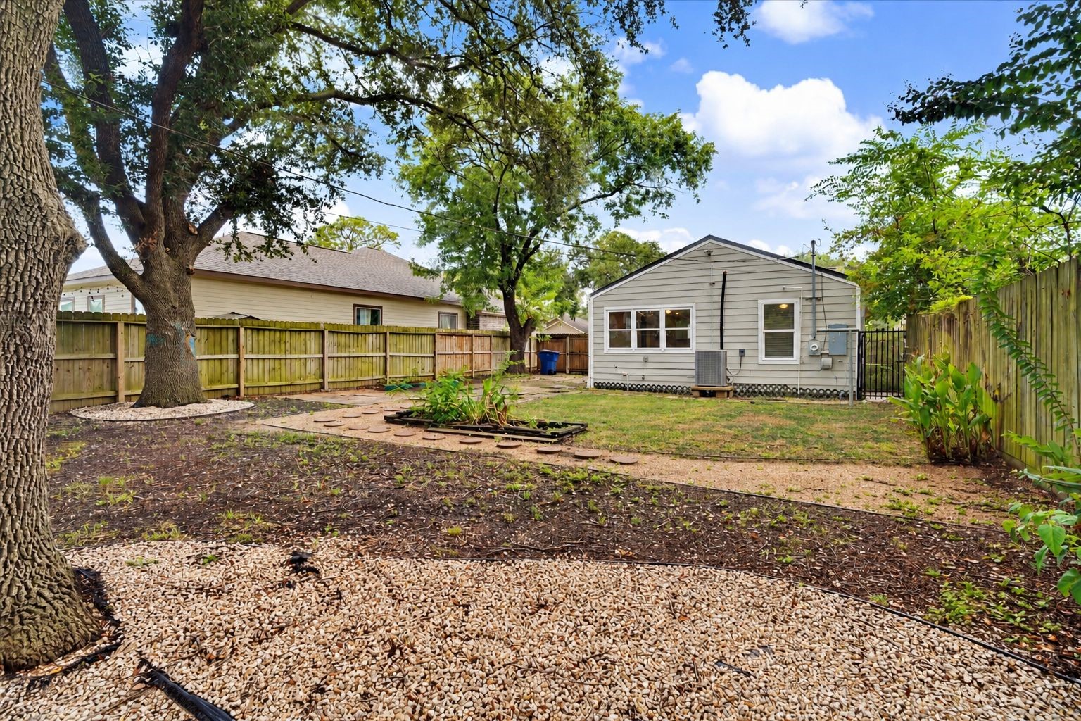 Spacious fenced backyard with mature shade trees and plenty of room to enjoy or personalize the outdoor space.