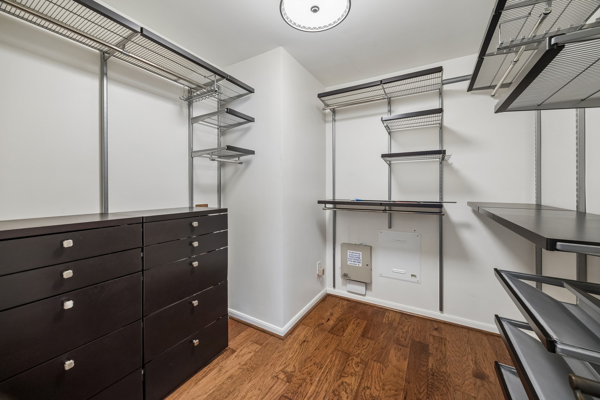 Second primary walk-in closet with custom built-in organization, including extensive hanging space, drawers, and open shelving.