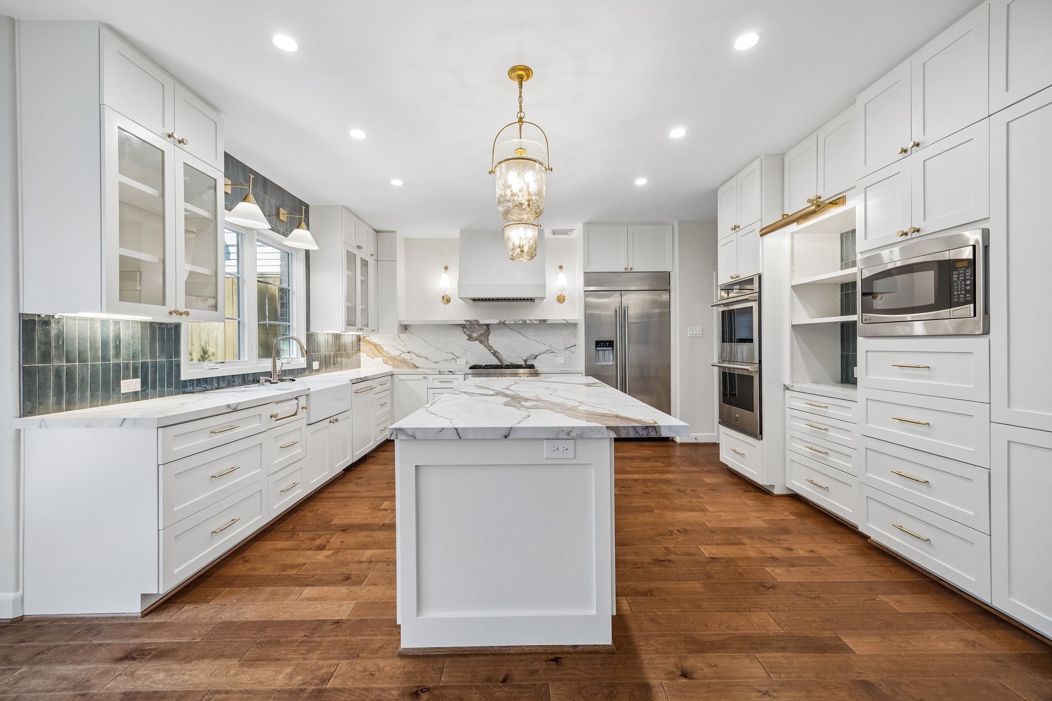 Thoughtfully designed kitchen with double ovens, a six-burner gas cooktop, and a built-in cup washer at the sink. Custom cabinetry maximizes storage with beautifully finished details inside and out.