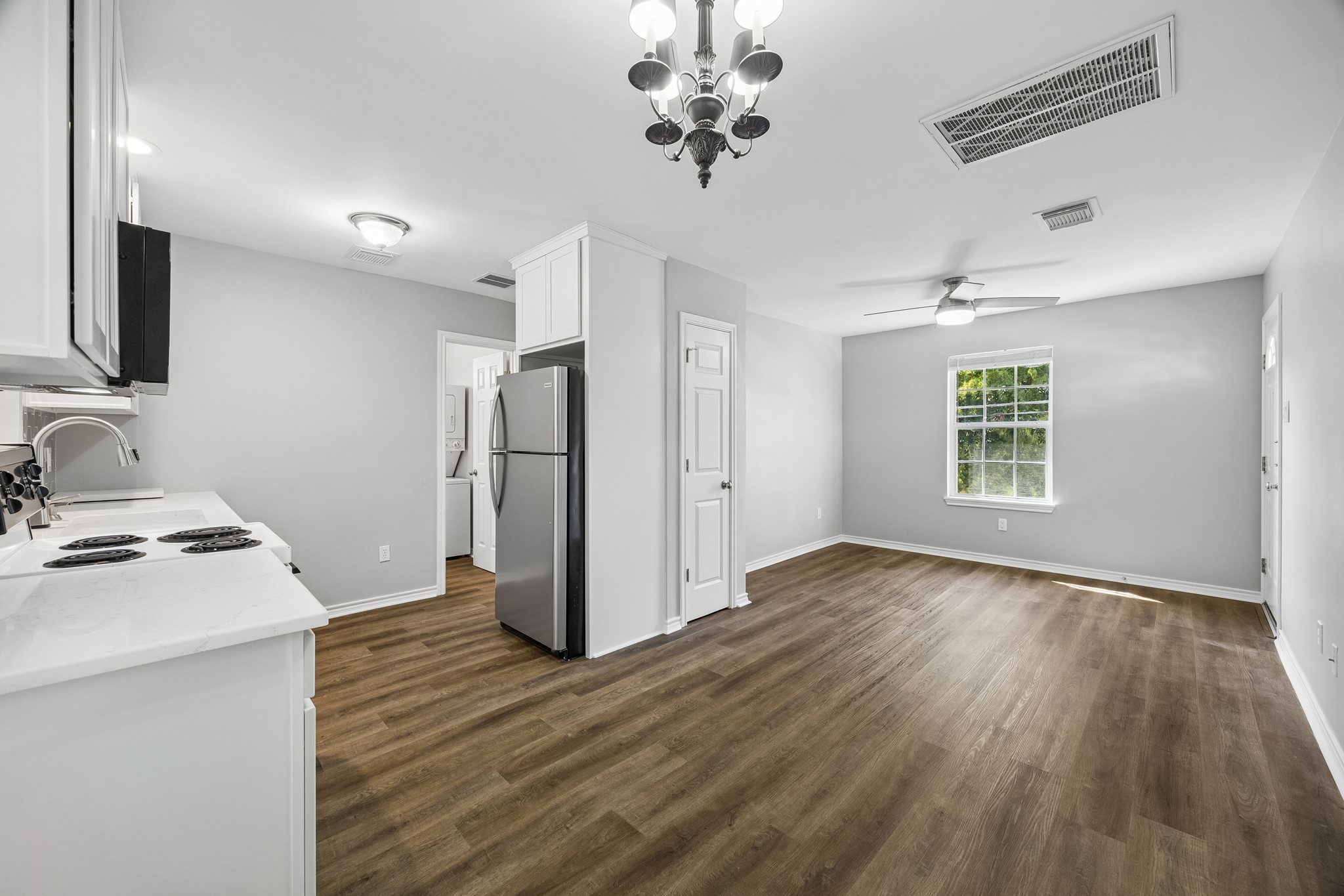 Detached garage apartment featuring engineered wood flooring, recessed lighting, and an open living area filled with natural light.