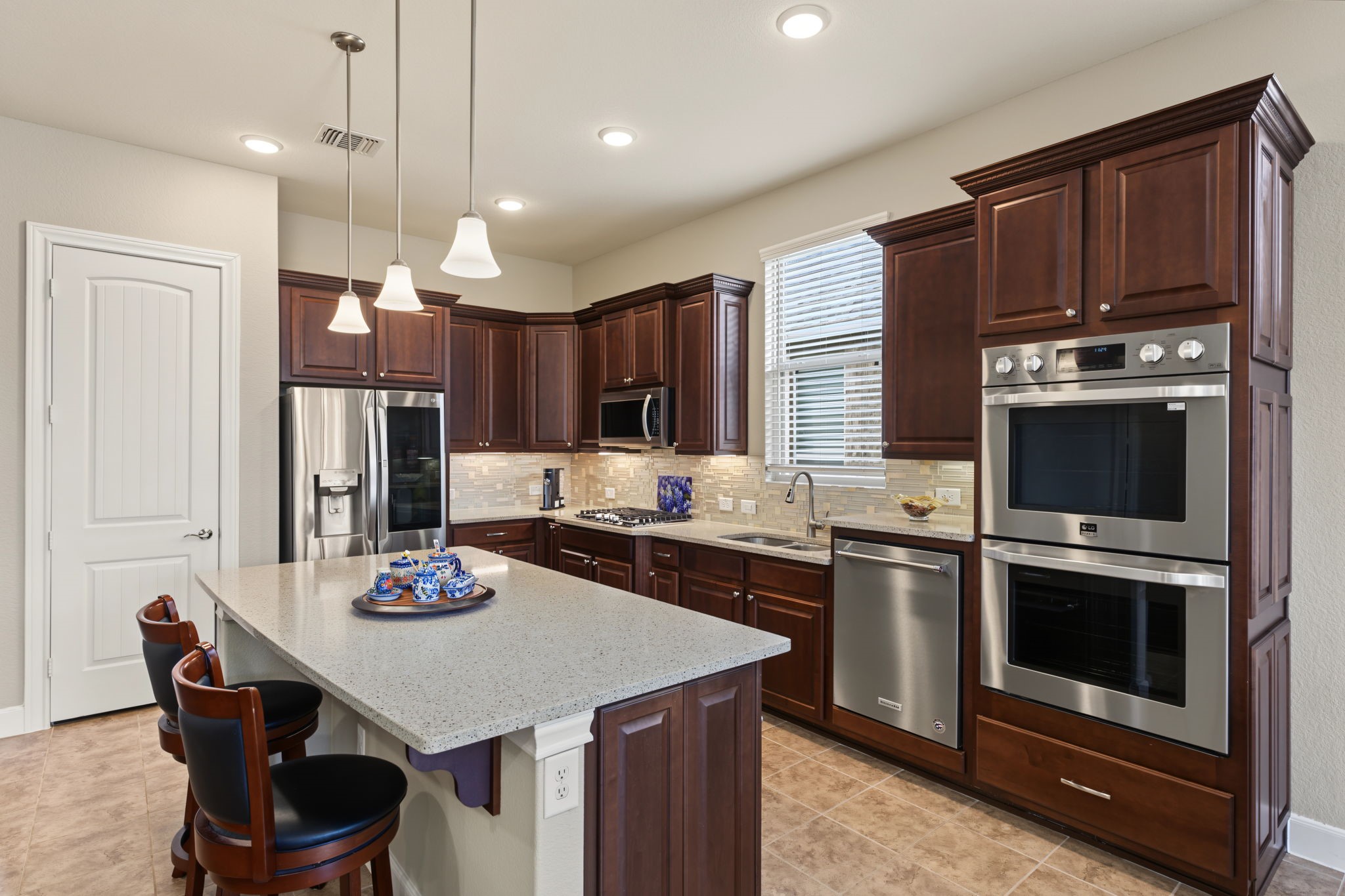 Stainless steel LG ovens and an elevated Kitchenaid dishwasher