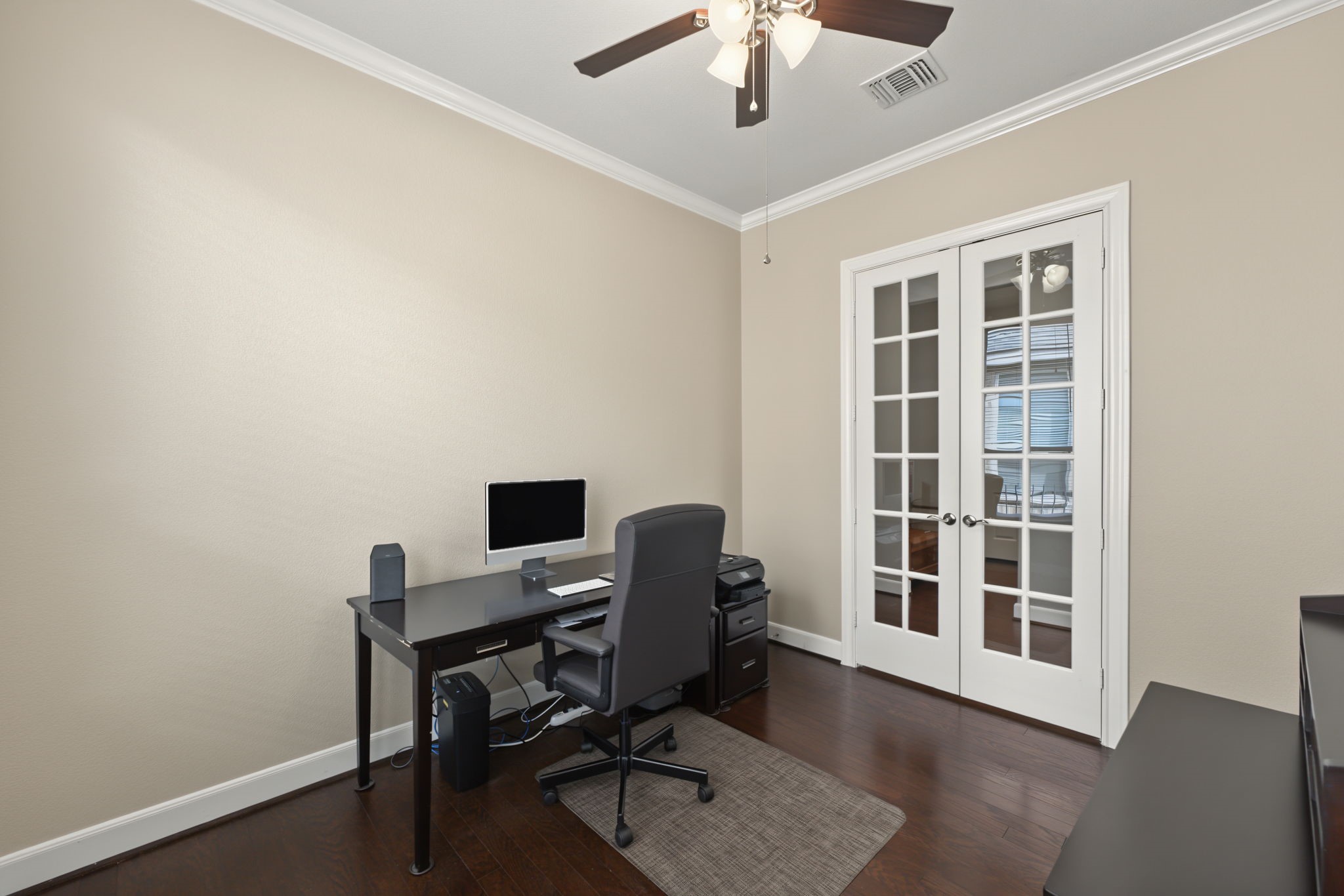 Home office/study has crown molding and ceiling fan.