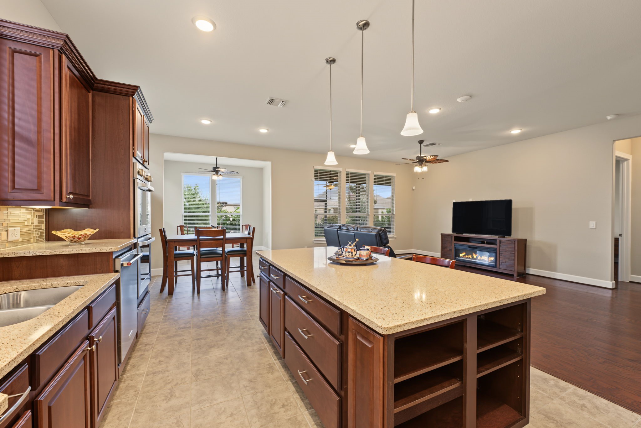 Breakfast area adjacent to the kitchen with a sunroom beyond the breakfast area.