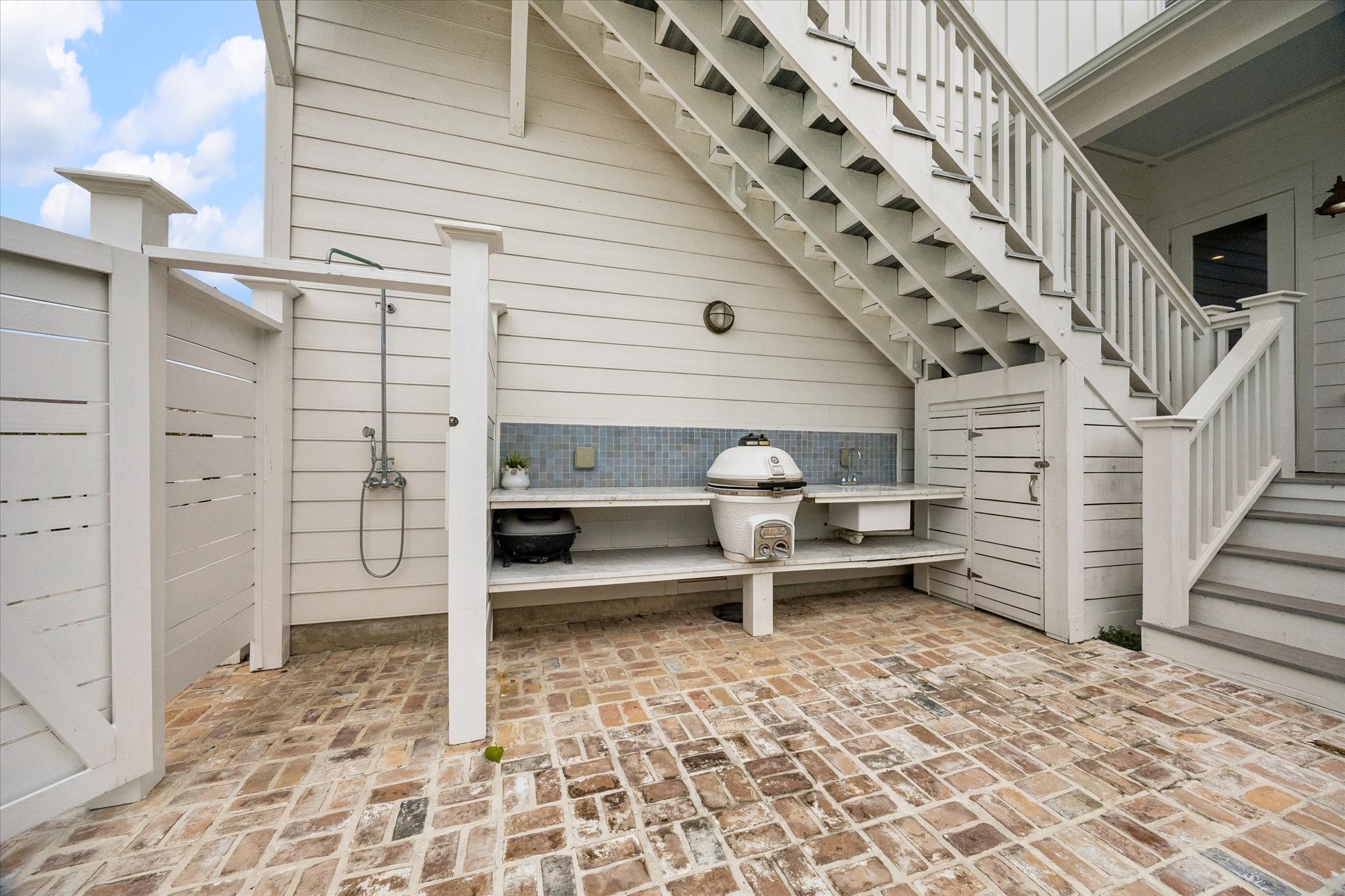 Outdoor kitchen and shower. Stairs to the 5th bedroom, bunk room or office