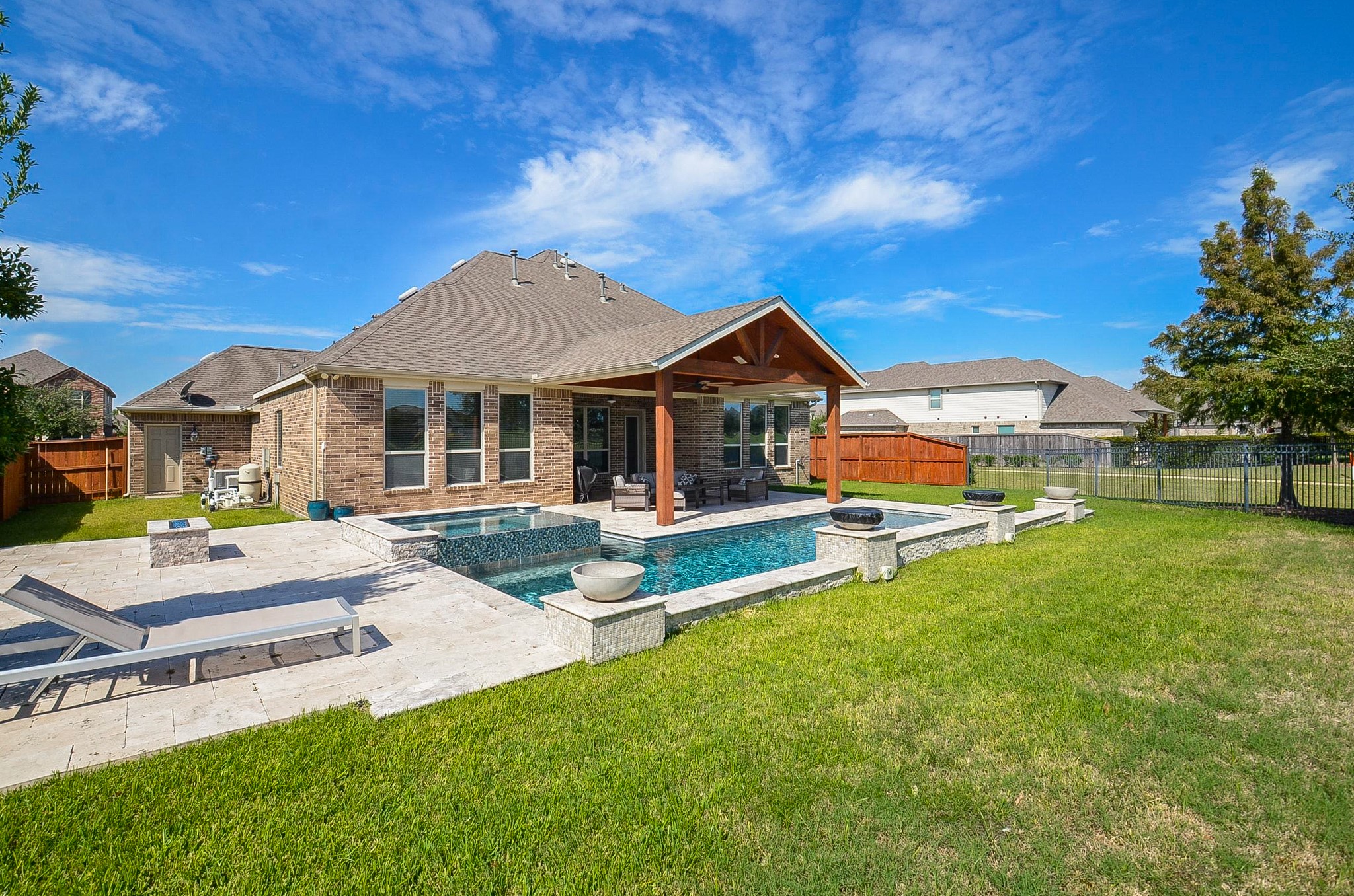 Stunning view of the home's exterior, featuring a beautiful covered patio and an inviting, resort-style pool!