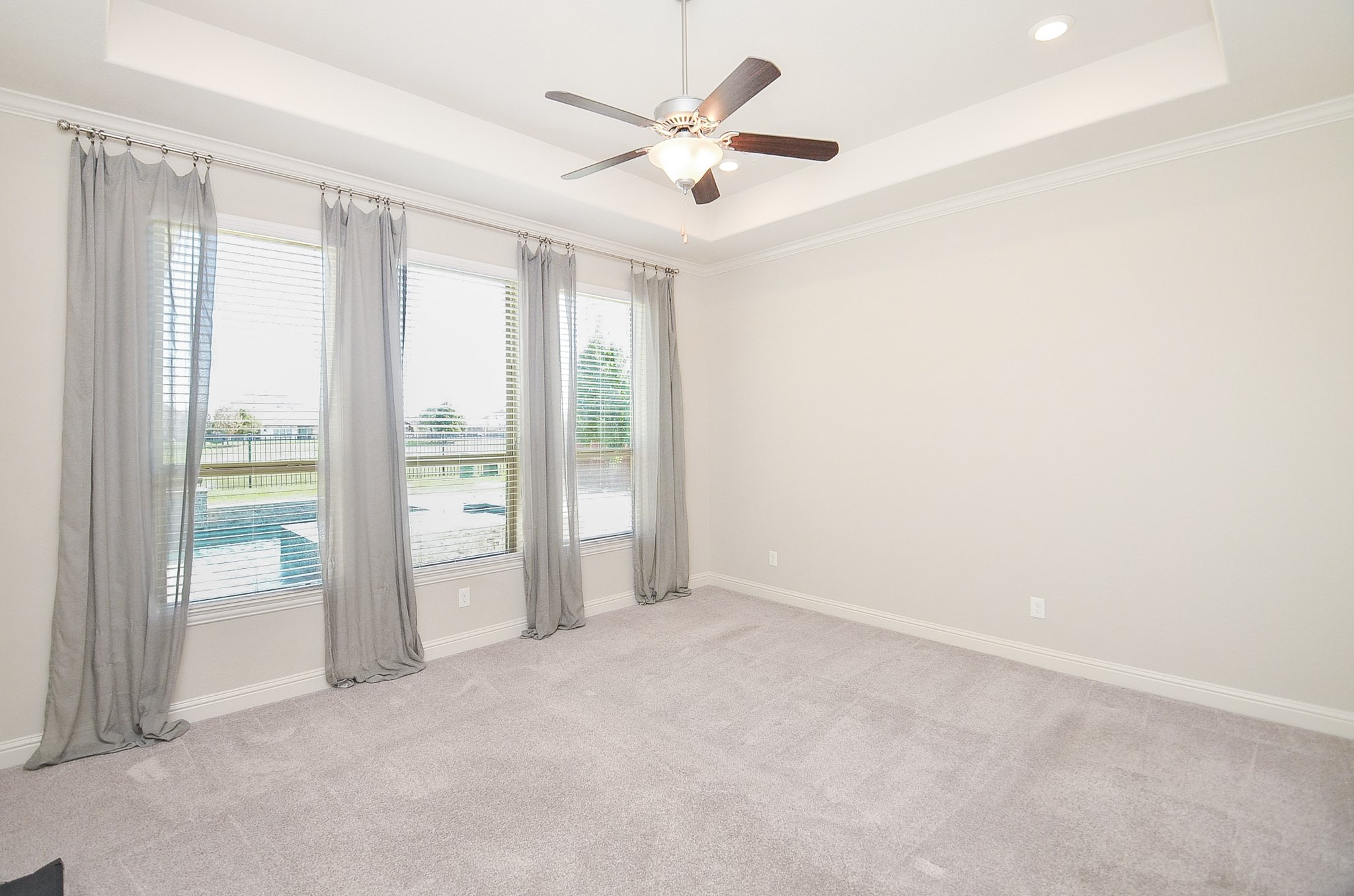 Master bedroom featuring large windows with views of the pool and lake!