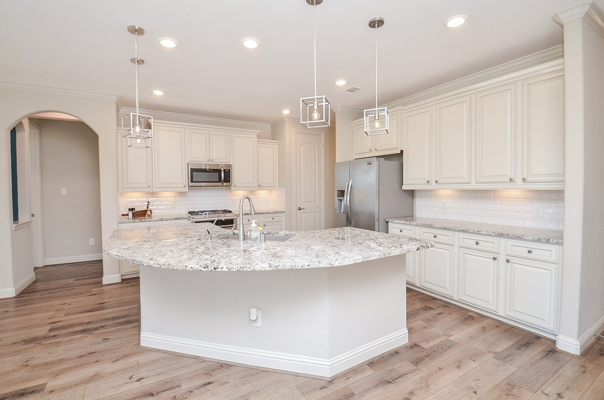Stunning kitchen featuring a large breakfast bar and an open-concept layout that flows seamlessly into the living room!