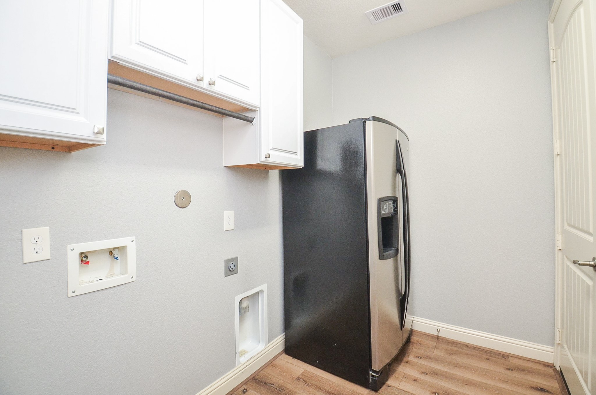 Large utility room featuring built-in cabinetry and dedicated space for an additional refrigerator!