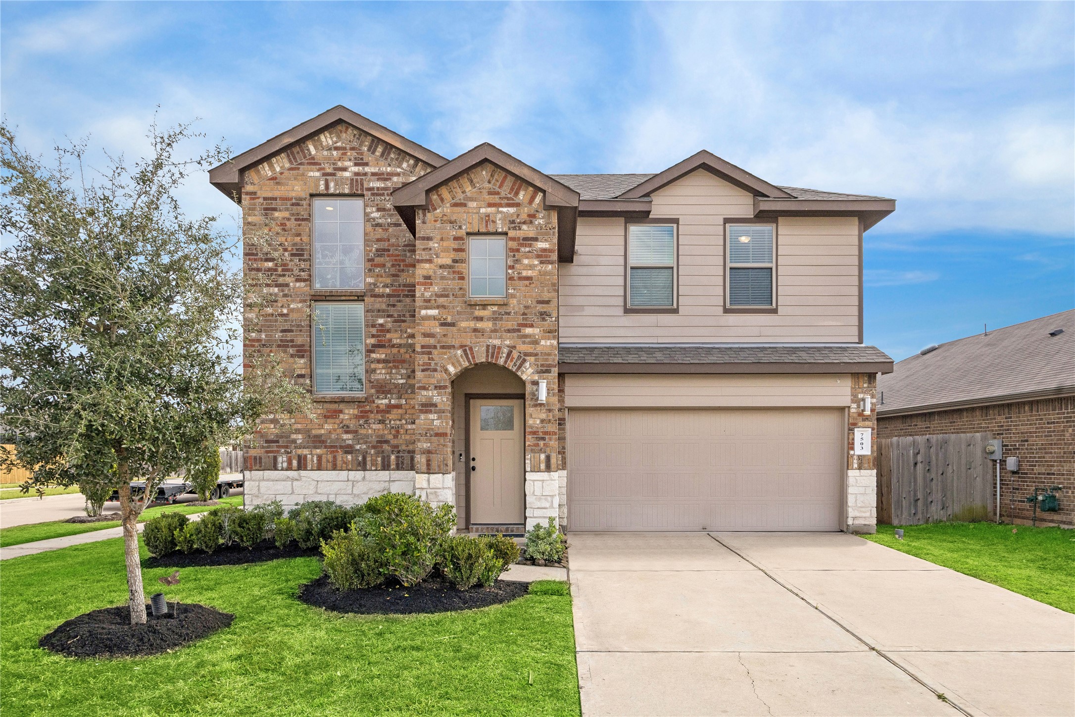 Brick and stone elevation delivers classic curb appeal with layered rooflines, manicured landscaping, and a recessed arched entry that adds depth and character to the faade. Brick and stone elevation delivers classic curb appeal with layered rooflines, manicured landscaping, and a recessed arched entry that adds depth and character to the faade.