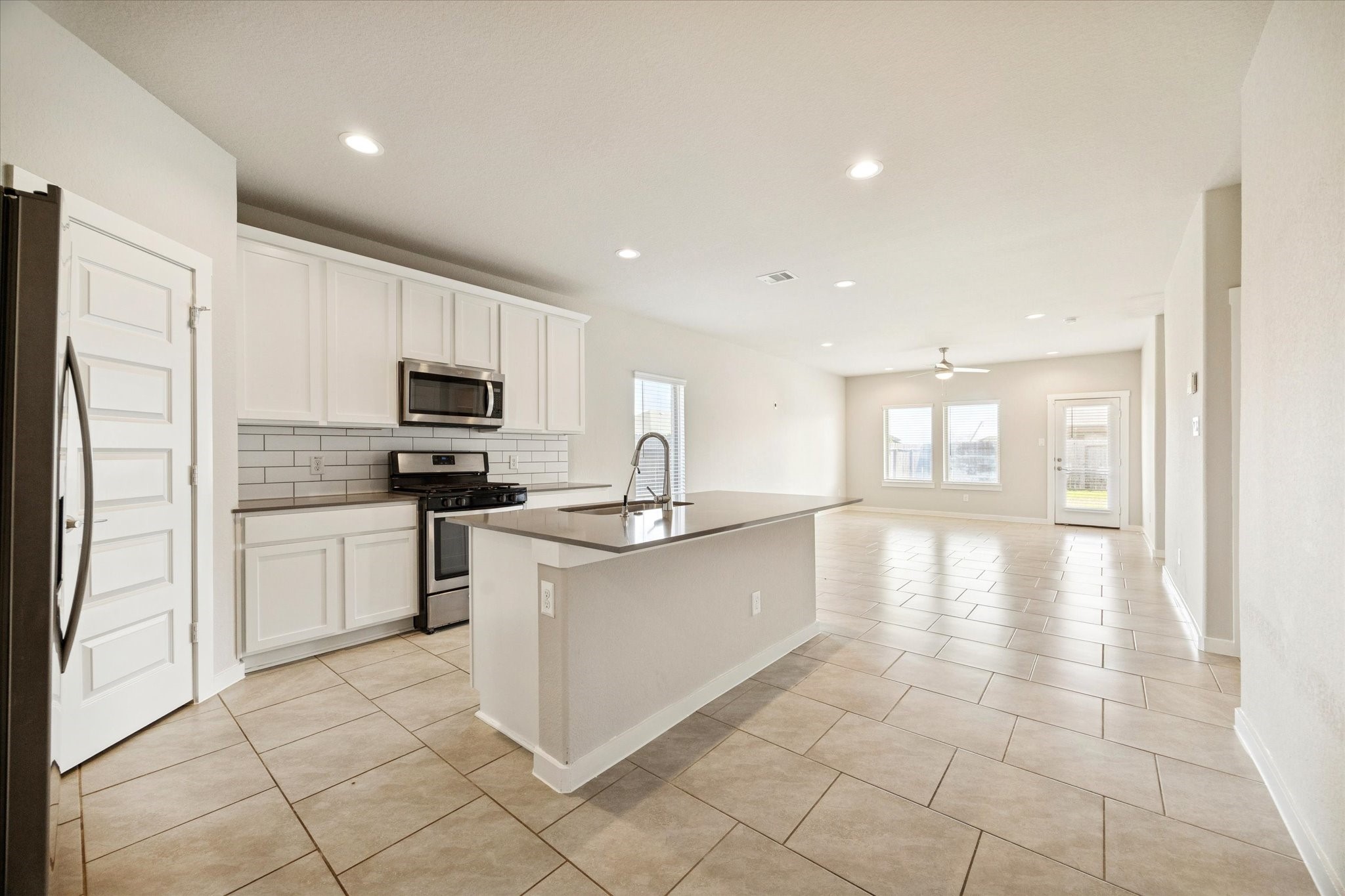 Clean-lined cabinetry, stainless appliances, and a subway tile backsplash create a bright, functional kitchen with timeless appeal.
