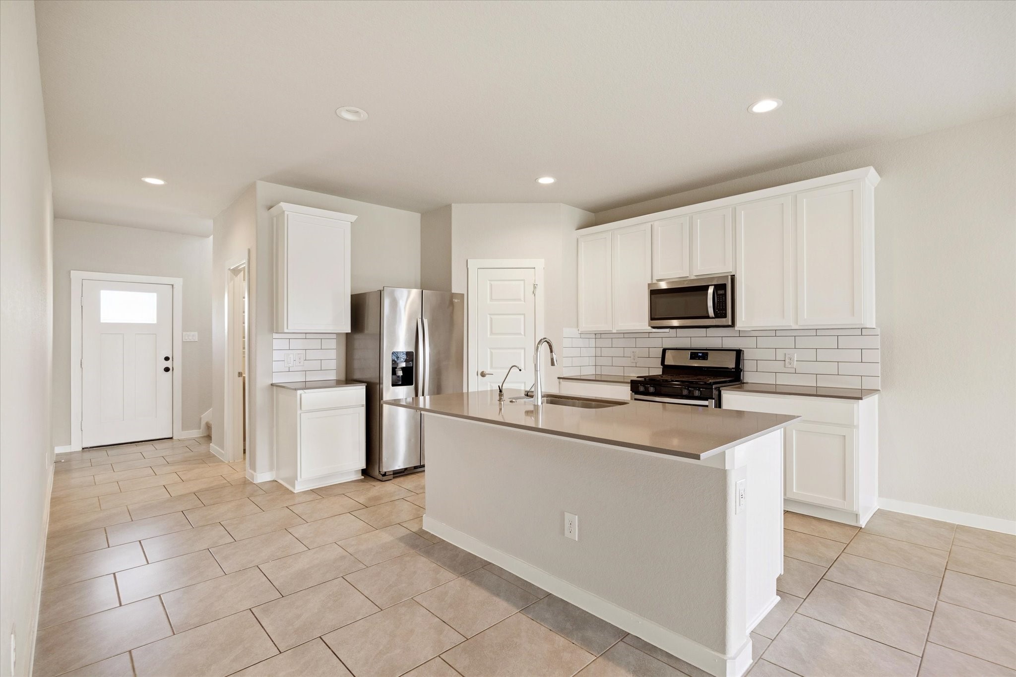 Central island anchors the kitchen with ample prep space, pendant-ready lighting points, and clear sightlines into the main living area.