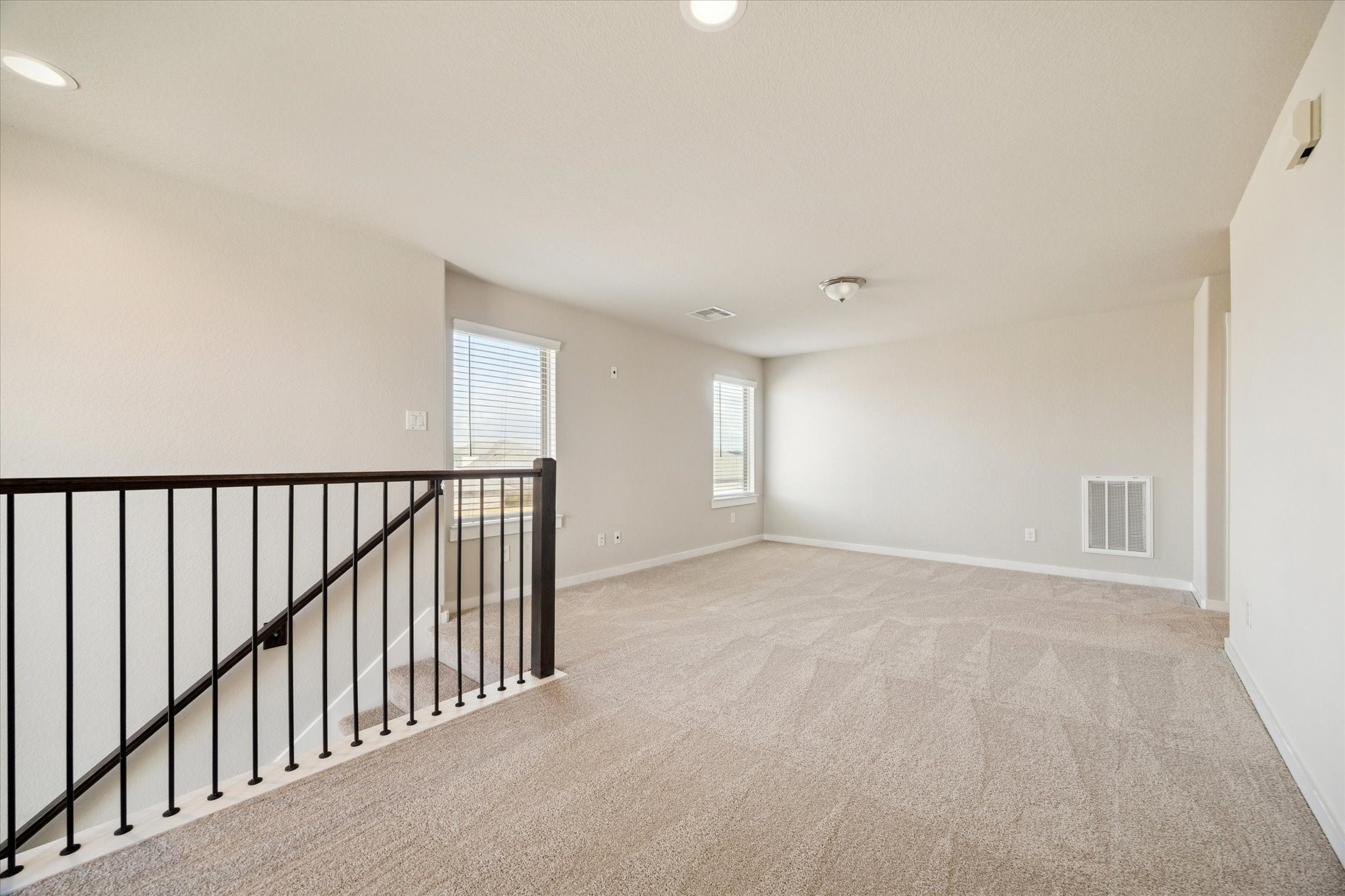 An open upper landing provides a flexible bonus area suited for a desk, reading nook, or additional seating. Natural light and open railing keep the space feeling connected while maintaining separation from private rooms.