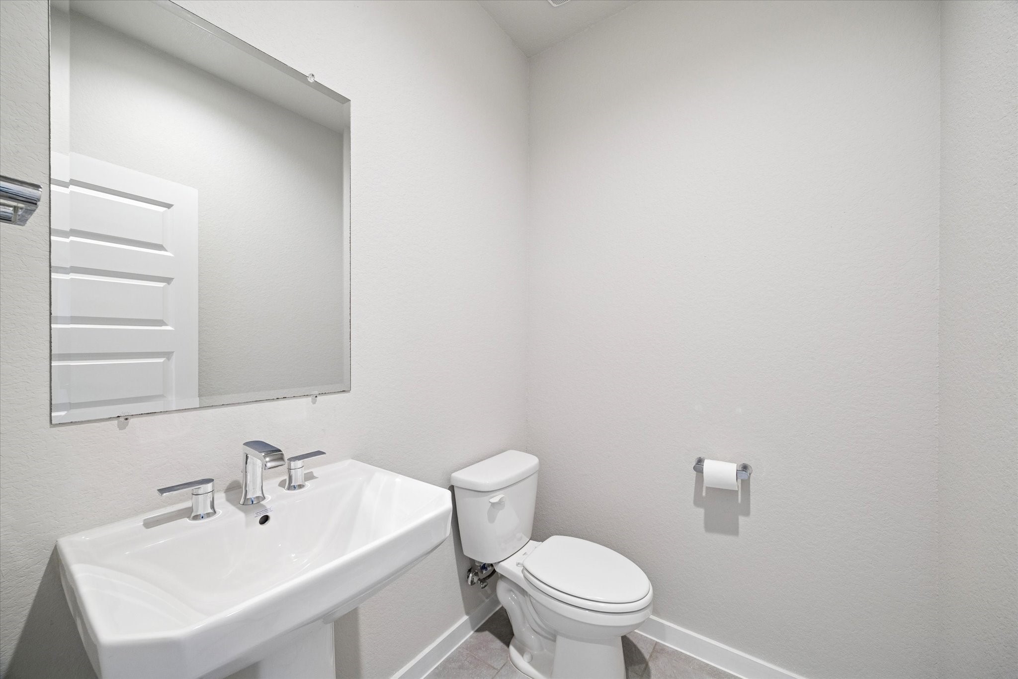 A clean, streamlined powder bath designed with simplicity and function in mind. The pedestal sink and large wall mirror keep the space feeling open and bright, while neutral finishes allow for easy personalization. Ideal for guests, this bath delivers practicality with a timeless, understated look.