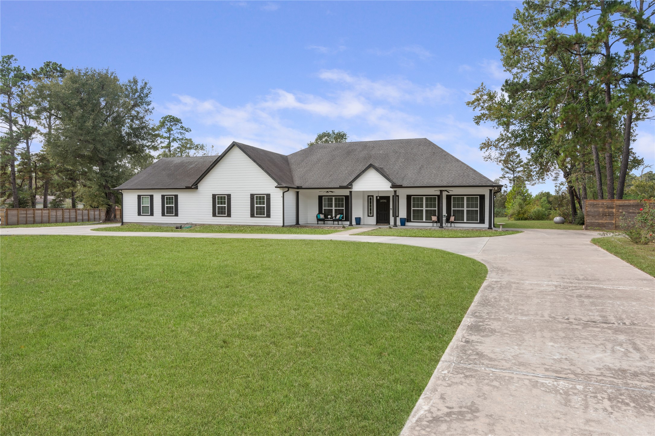 Expansive driveway and generous space alongside the home offer room for additional vehicles, an RV, boat, or trailer.