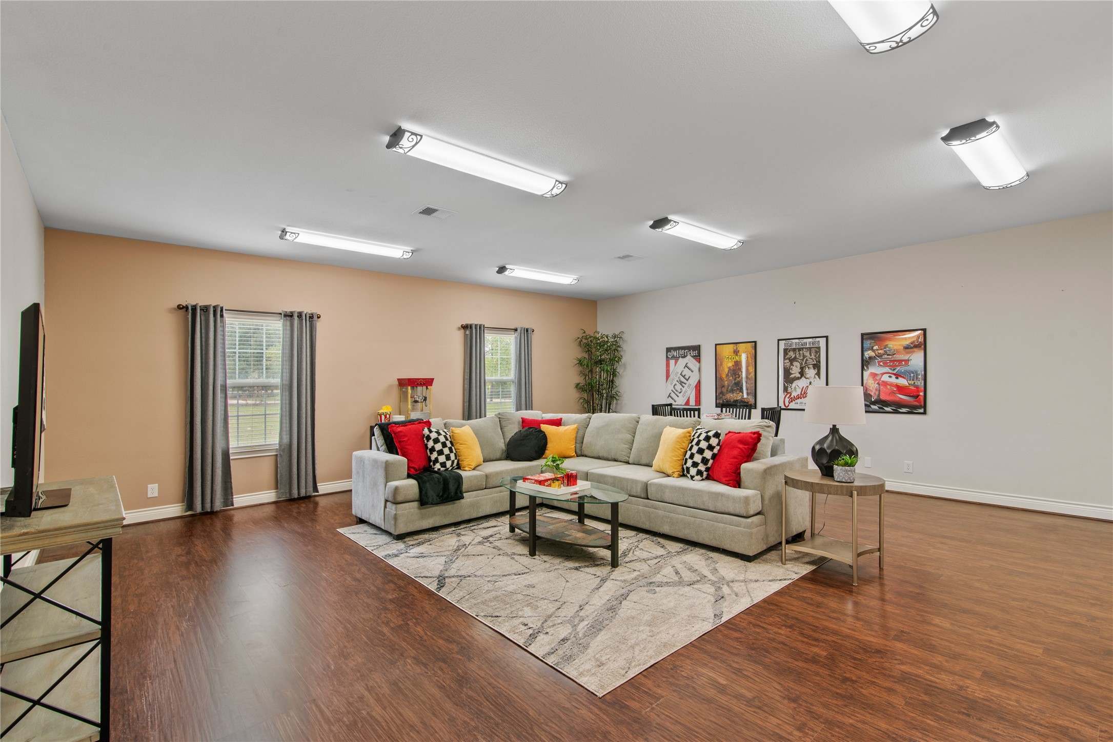 Oversized fourth bedroom, currently staged as a game room, with ample space for a large sectional, movie nights, and recreation.