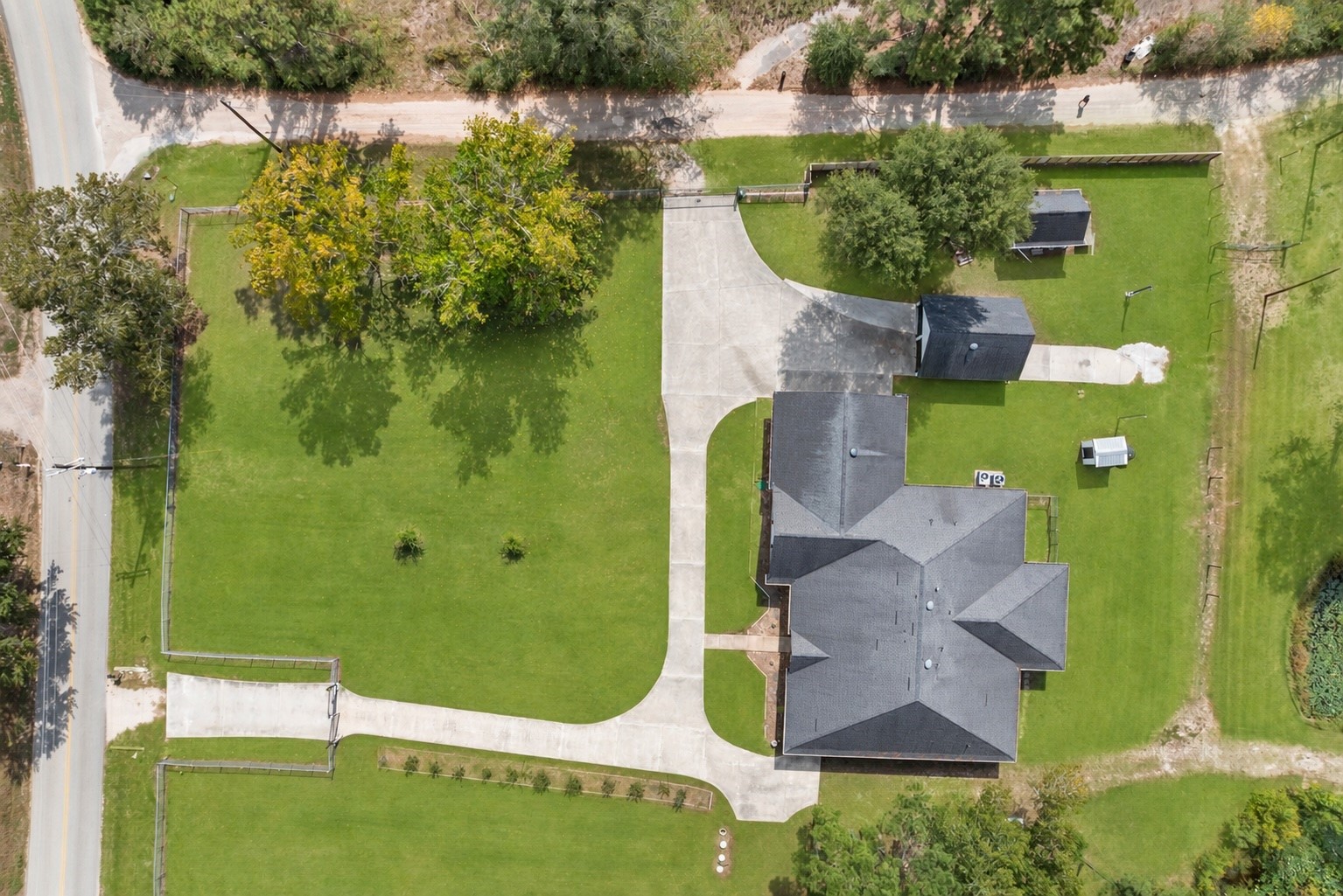 Full driveway view highlights two separate entrances with automatic gates, providing convenient access and easy circulation throughout the property.