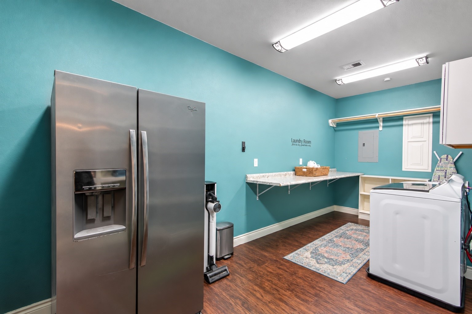 A generous counter space provide a handy area for laundry tasks, with additional room for a second refrigerator.