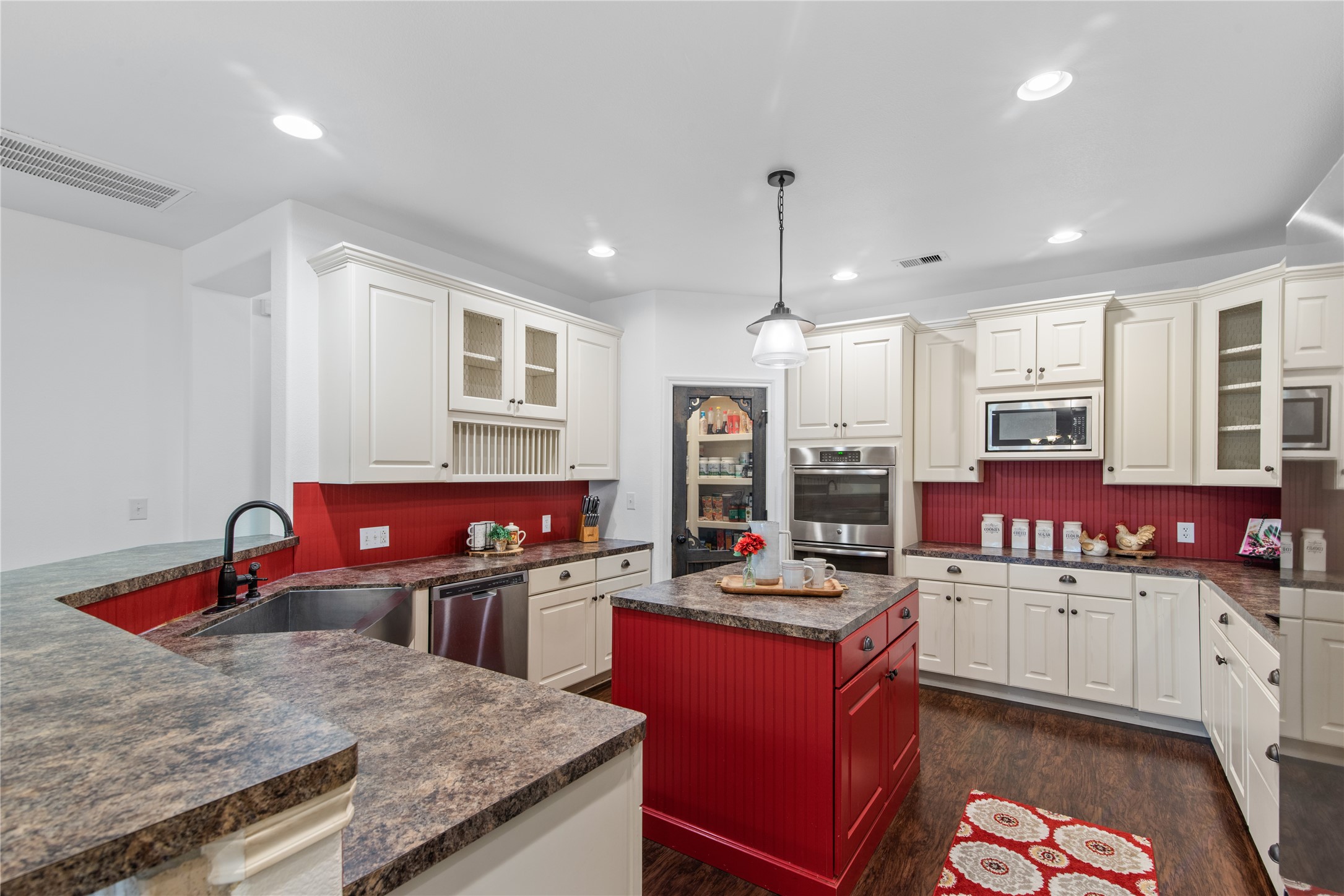 Spacious kitchen featuring abundant cabinetry, a center island, double ovens, and a walk-in pantry.