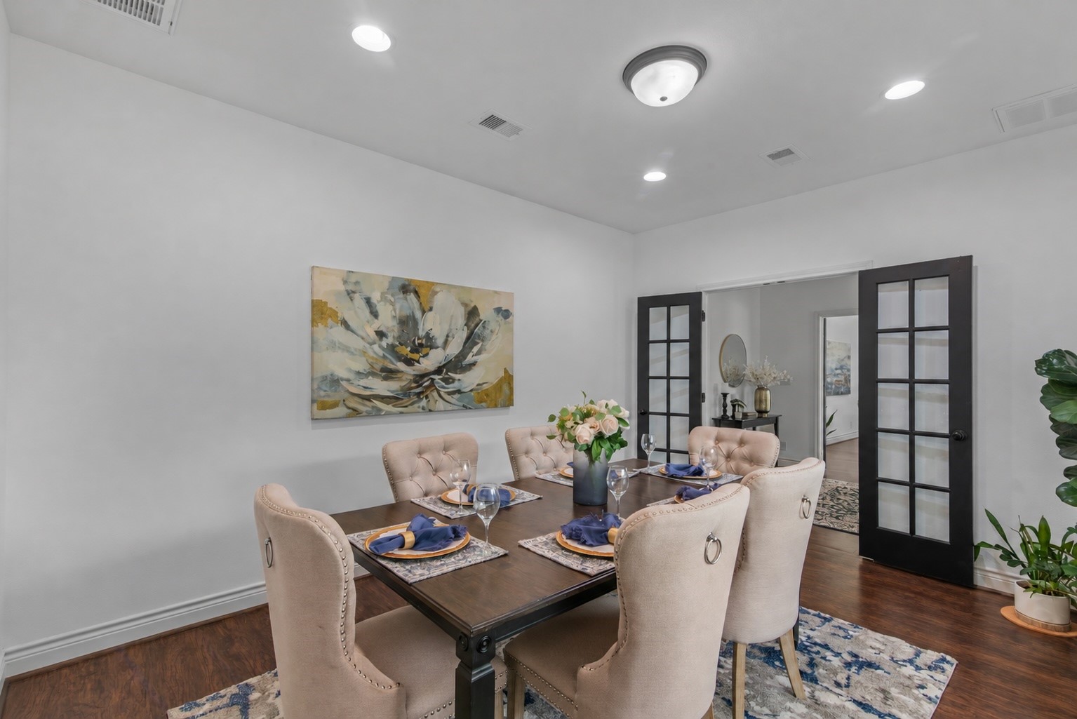 French doors connect the formal dining space to the entry, while recessed lighting creates a bright setting for hosting family and friends.