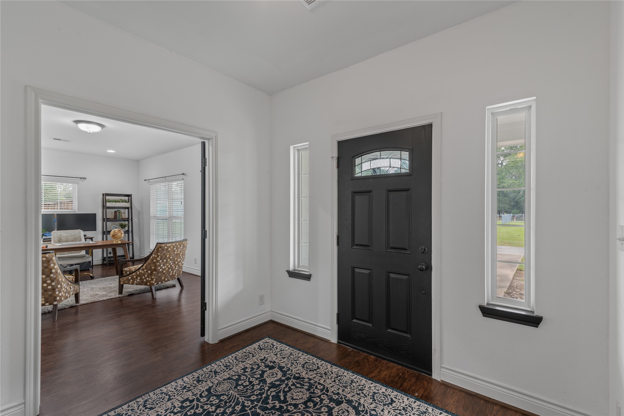 A striking black front door with decorative glass and flanking sidelights brings character and natural light to the large entry.