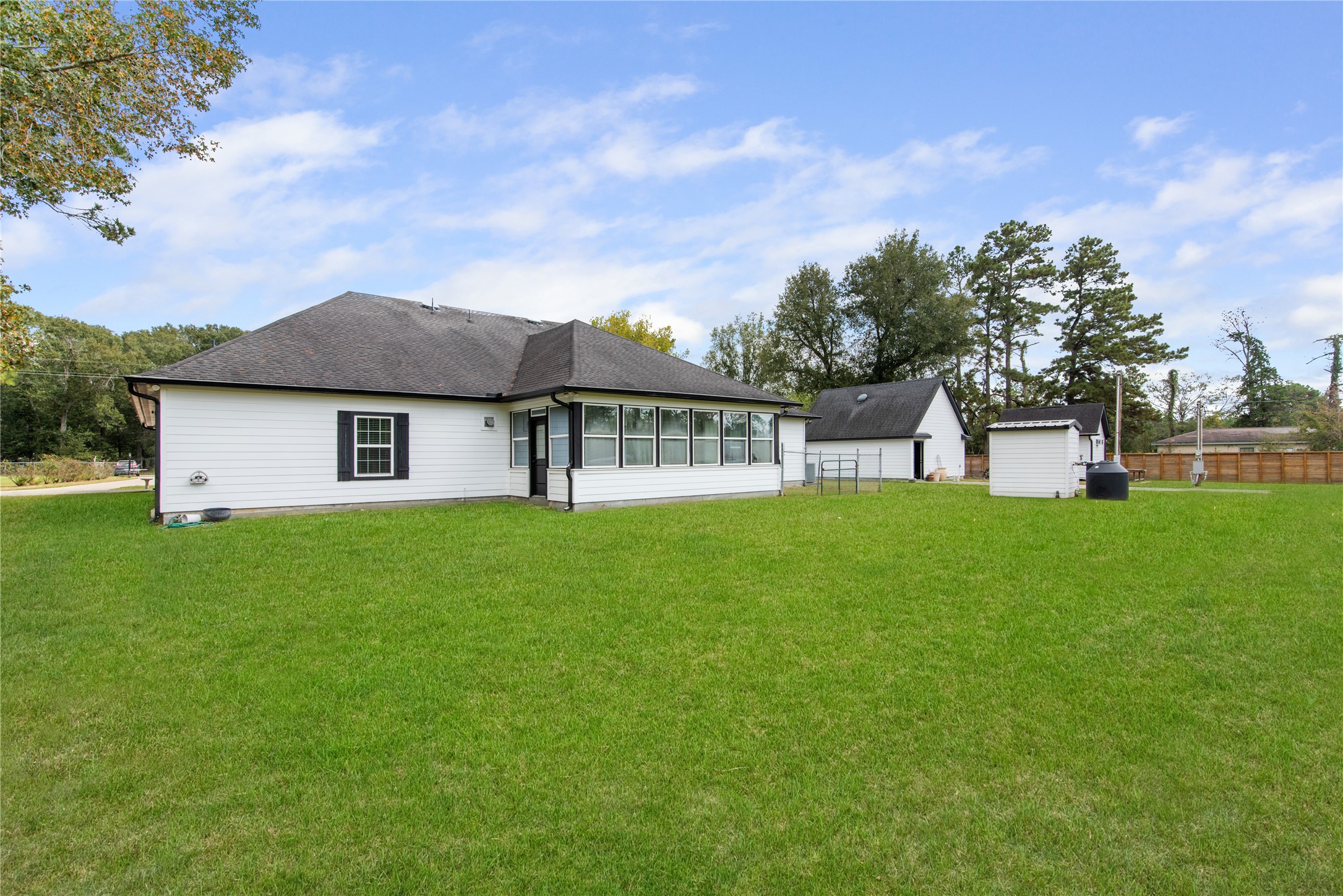 Expansive backyard with a view of the propertys private water well, workshop, and detached garage, offering versatile space for projects, storage, and outdoor enjoyment.