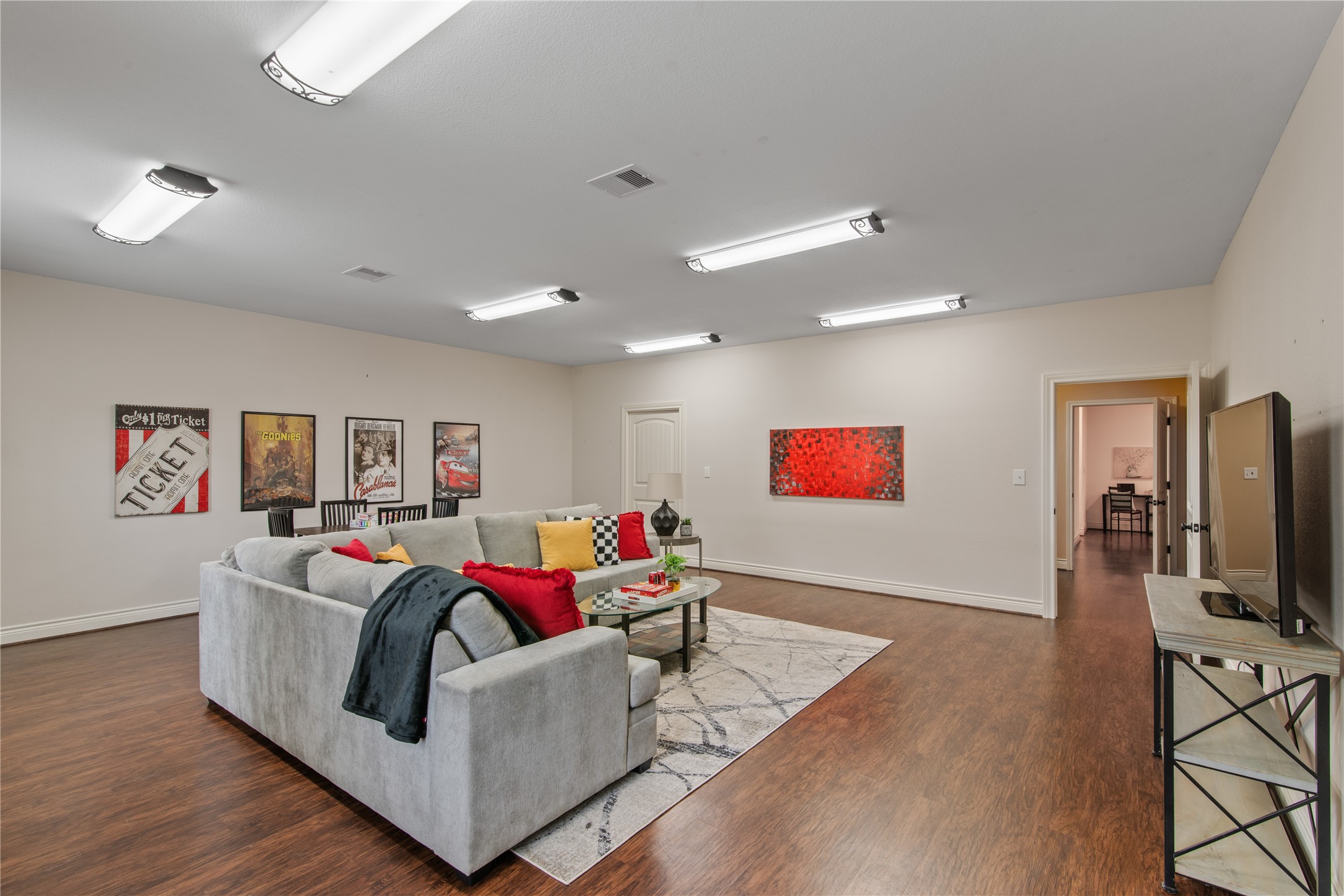 Tucked away from the main living areas just off the mudroom and laundry room, this oversized fourth bedroom offers a private retreat, currently staged as a game room.