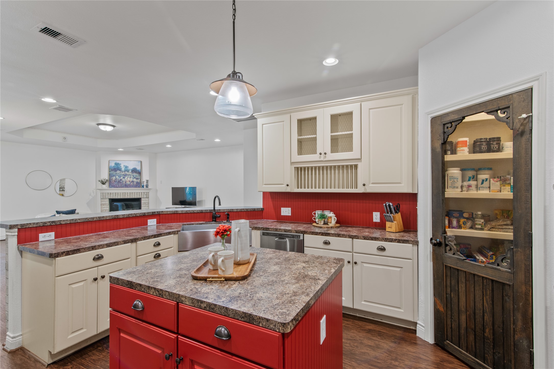 A farmhouse-style sink, built-in plate rack, and decorative wood pantry door bring charm and practical touches to the kitchen.