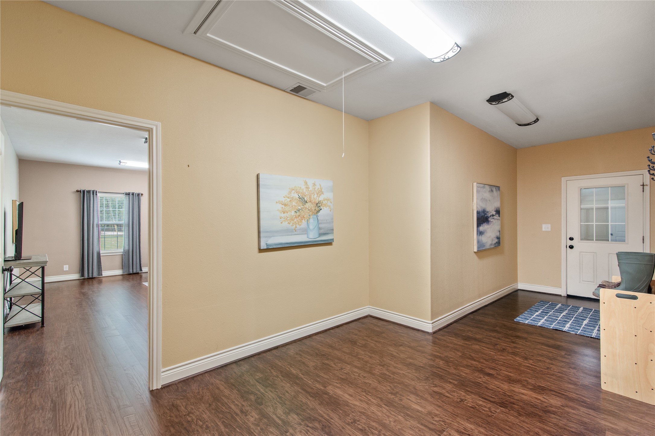 Spacious mudroom leading to the garage, offering plenty of room to create an organized drop zone for shoes, coats, and everyday essentials.