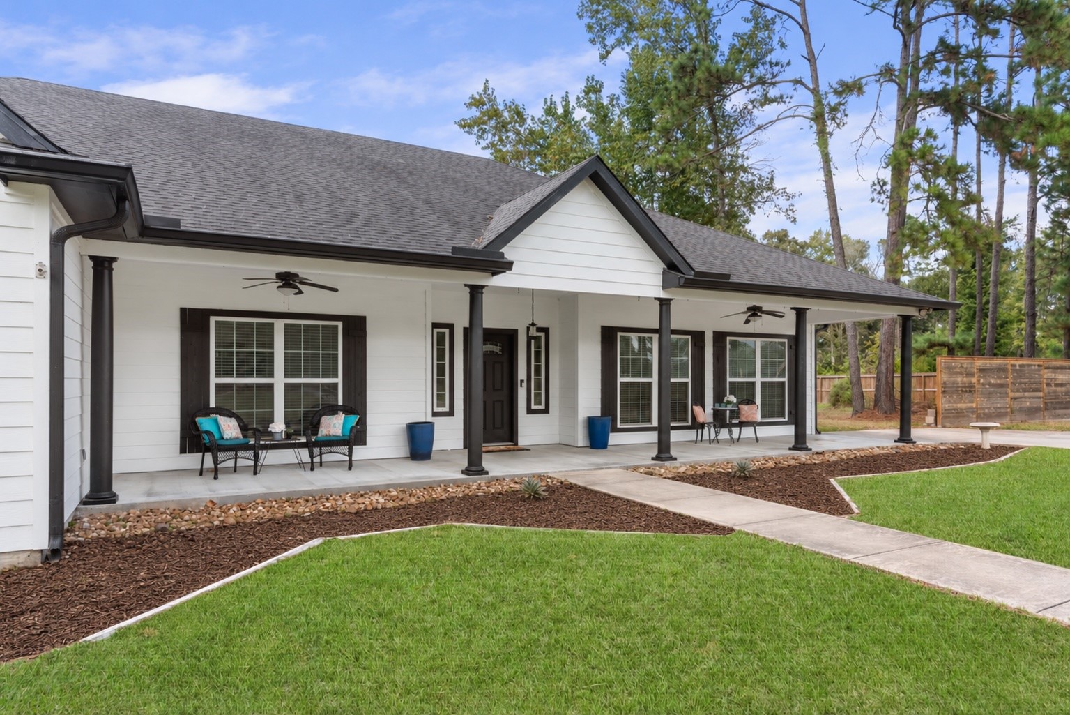Enjoy morning coffee or unwind on the spacious covered front porch, featuring ceiling fans and plenty of room for multiple seating areas.